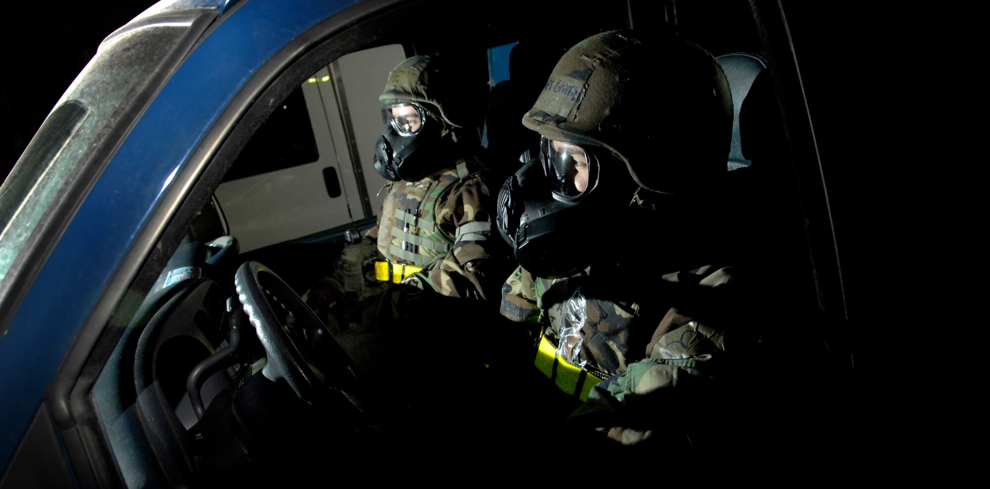 Senior Airman James Griffith (Right) and Senior Airman Isaac King take cover in an aircraft hanger as Osan Air Base goes into Alarm Blue, MOPP 4, during the Operational Readiness Exercise Beverly Bulldog 09-02, March 31. The pre-scheduled exercise is designed to help the 51st Fighter Wing prepare for their Operational Readiness Inspection in April. (U.S. Air Force photo/Staff Sgt. Brian Ferguson)