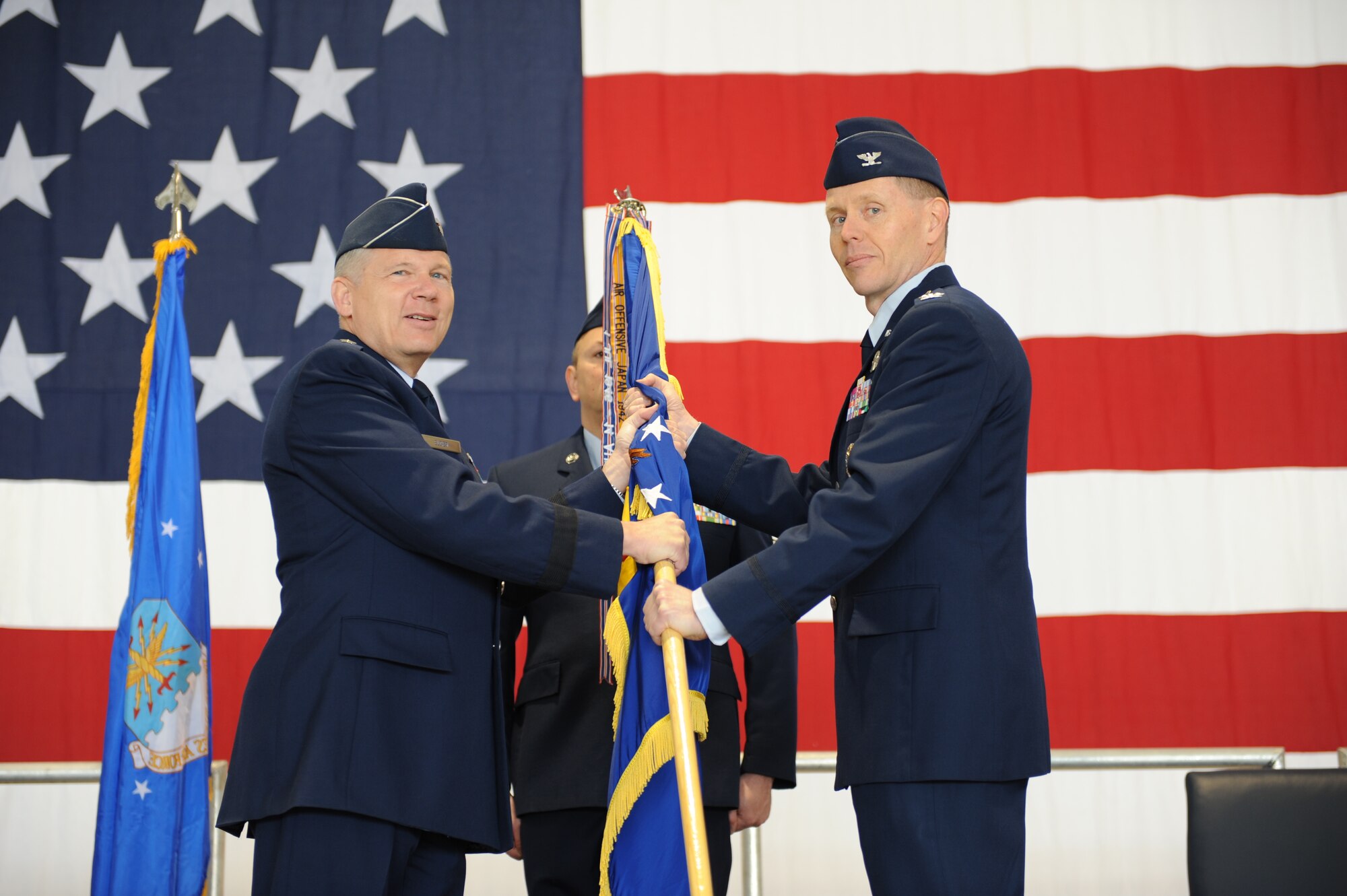 WHITEMAN AIR FORCE BASE, Mo. - Lt. Gen. Robert Elder, 8th Air Force commander, transfers the 509th Bomb Wing guidon to Col. Robert Wheeler from Brig. Gen. Garrett Harencak during the change of command ceremony here March 24. Presentation of the guidon to Colonel Wheeler symbolizes the official change of command from General Harencak to Colonel Wheeler. (U.S. Air Force photo/Staff Sgt. Charles Larkin) 