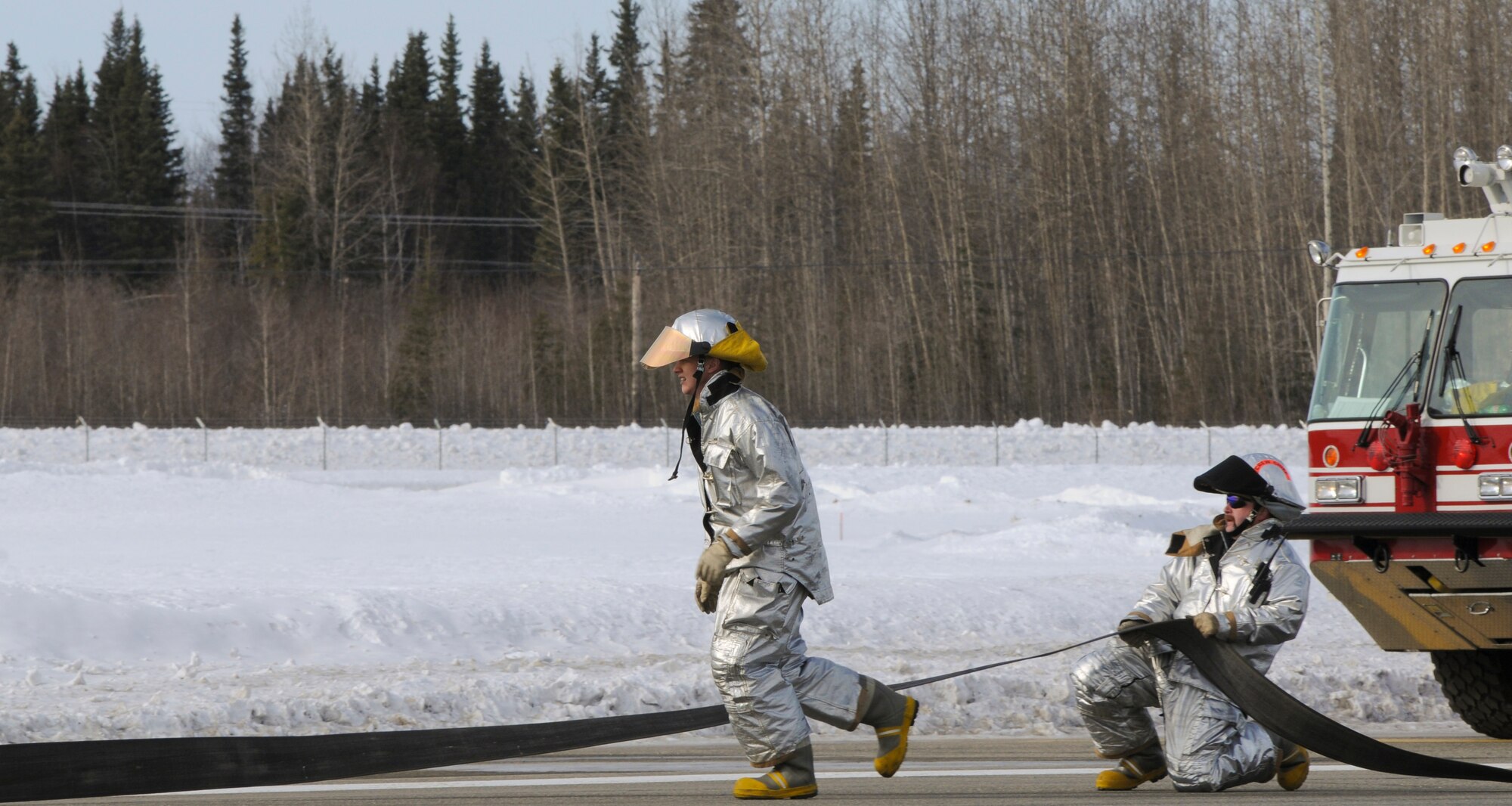 Airmen from the base fire department check the emergency arresting cable for wear during an annual emergency break barrier test, March 25, 2009, Eielson Air Force Base, Alaska. It is a team effort among the Eielson fire department, barrier maintenance crew, the crash recovery crew, and airfield 