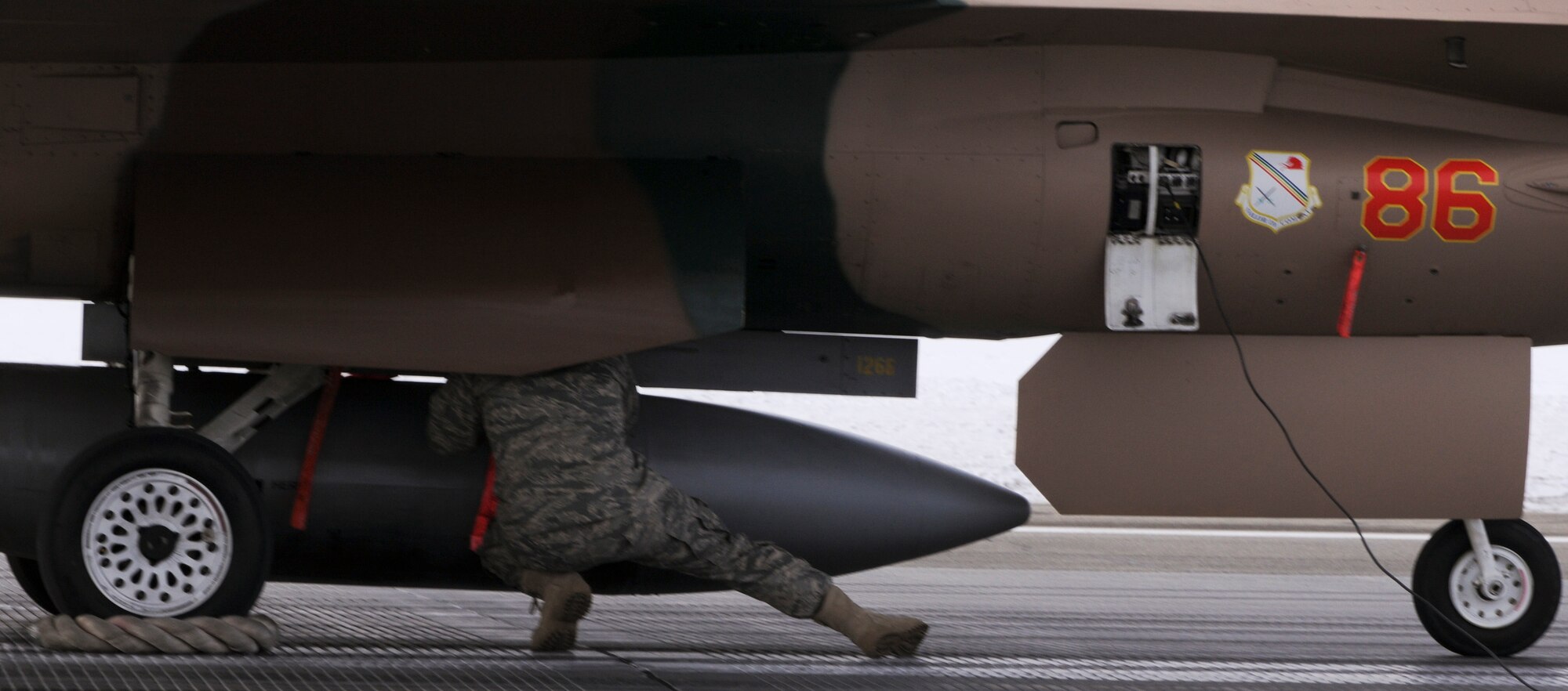A crew chief replaces pins on an F-16 Fighting Falcon, March 25, 2009 Eielson Air Force Base, Alaska.  The pins are removed prior to flying after being inspected by the flight crew. (U.S. Air Force photo/Airman 1st Class Laura Max)