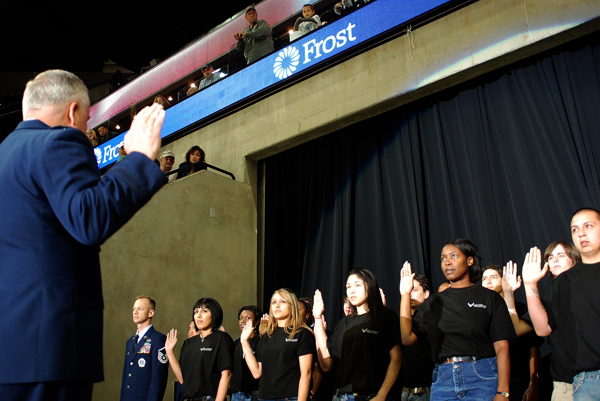 Future Alamo Wing reservists enlist during a mass enlistment ceremony held between the first and second periods of a San Antonio Rampage hockey game. The new members of the U.S. Air Force Reserve were welcomed by cheers and applause from the fans nearly filling the stadium. Brig. Gen. John C. Fobian, 433rd Airlift Wing commander, conducted the ceremony and, followed by members of the 433rd Recruiting Squadron, was the first to welcome the Alamo Wing's 15 newest members. The new Recruits will begin Air Force Basic Military Training at various times in the next few months. (U.S. Air Force Photo/Airman Brian McGloin)