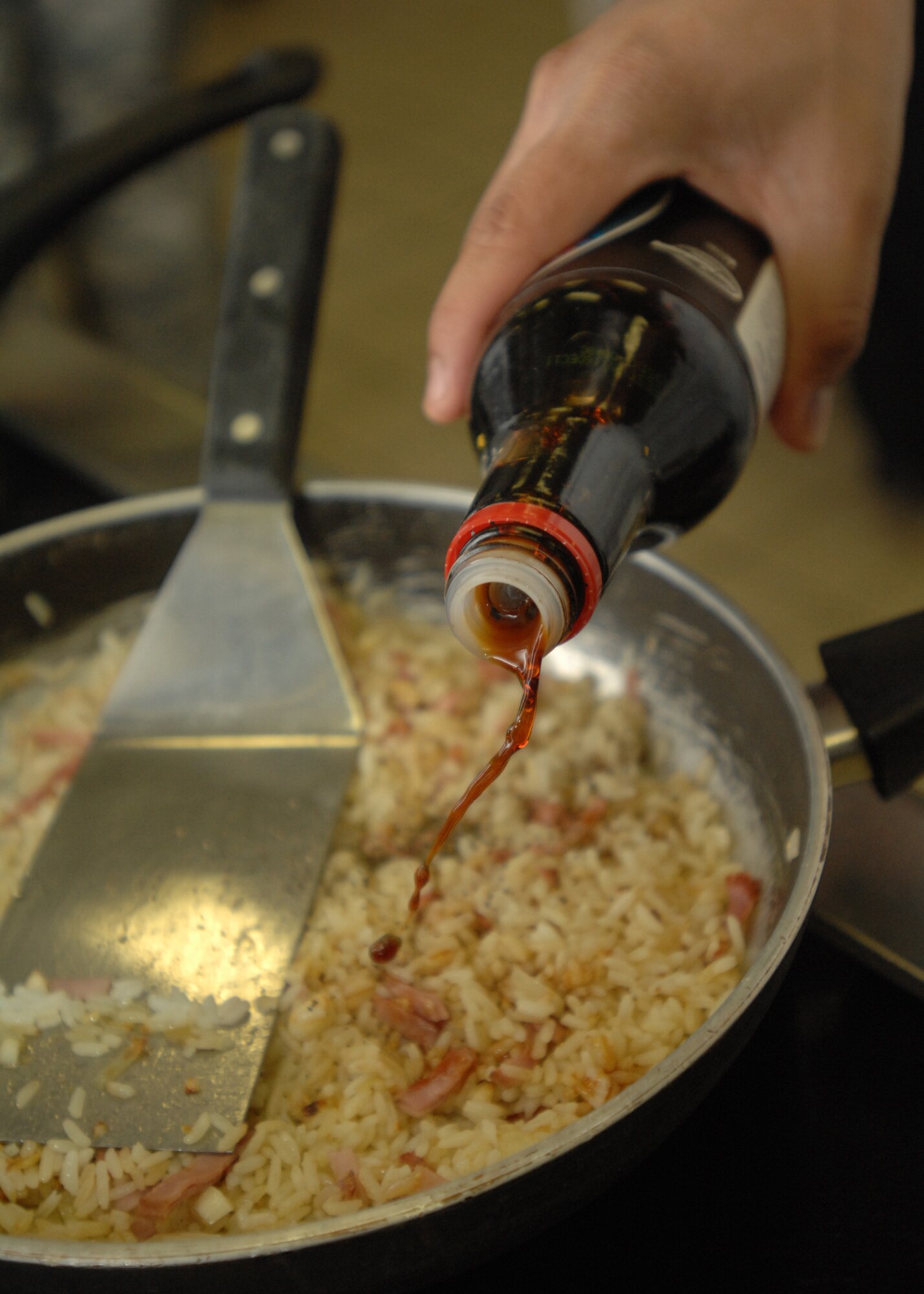 SPANGDAHLEM AIR BASE, Germany -- Soy sauce is poured onto rice March 30, 2009 during the Iron Chef competition at the Mosel Dining Facility. Two teams of four competed for the coveted title of Iron Chef by creating three main dishes using a limited number of ingredients and only three hours of cook time before being tasted by a panel of judges. (U.S. Air Force photo by Senior Airman Jenifer H. Calhoun)