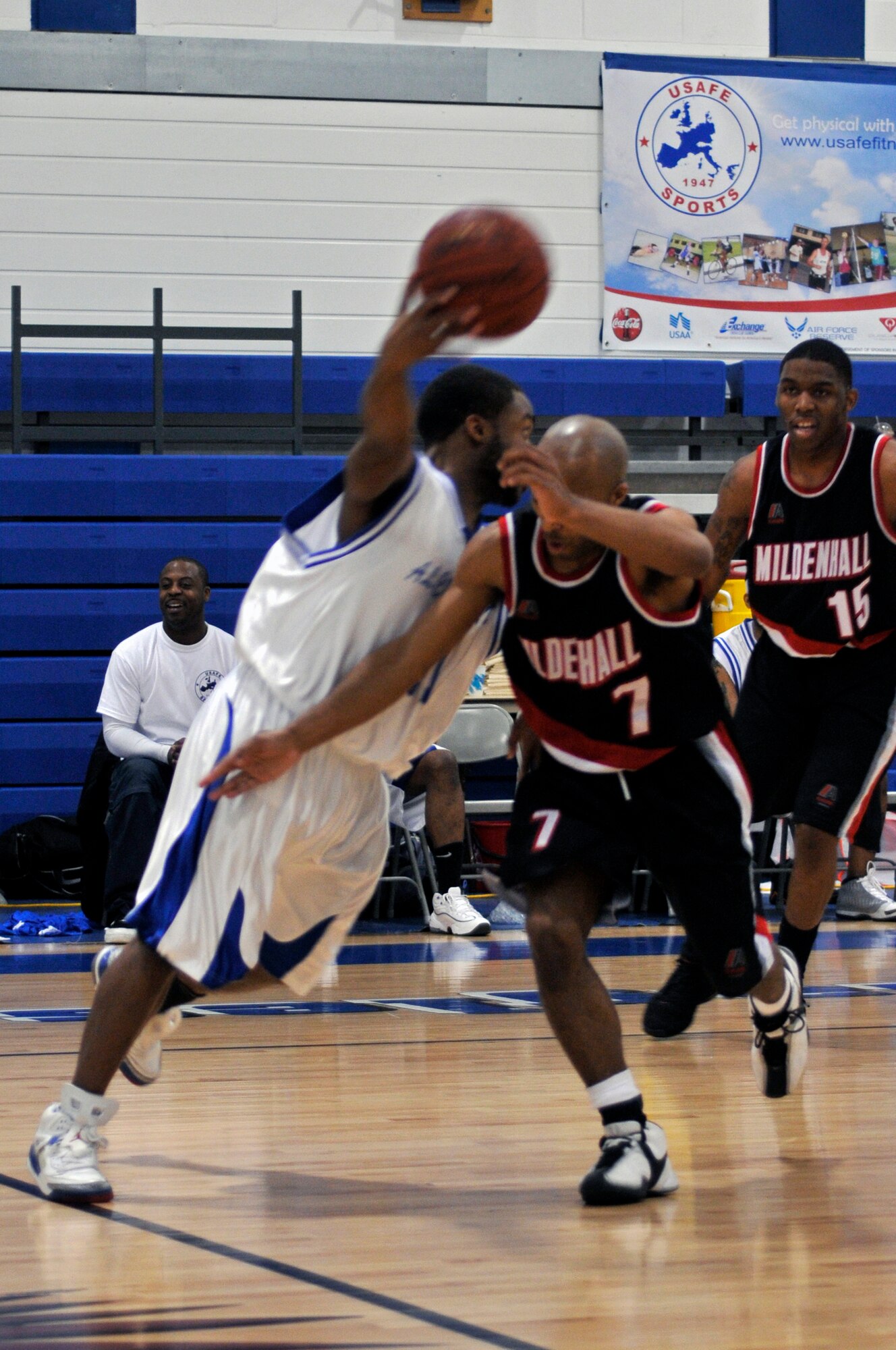 Kurt Frair, point guard for the 501st Combat Support Wing and husband of Senior Airman Amanda Frair, 423rd Medical Squadron, maneuvers around Mildenhall players,  March 26, 2009 at RAF Lakenheath, England. Teams from six bases in USAFE participated in the championships. (U.S. Air Force photo by Airman 1st Class Perry Aston) 