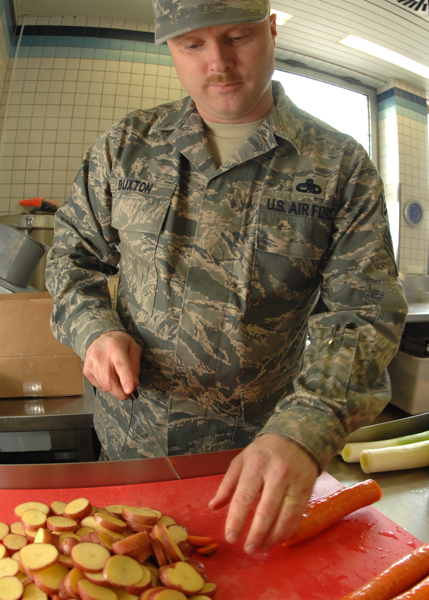 SPANGDAHLEM AIR BASE, Germany -- Chief Master Sgt. Jeff Buxton, 52nd Aircraft Maintenance Squadron, chops potatoes and carrots for Team Stinger March 30, 2009 during the Iron Chef competition at the Mosel Dining Facility.  Chief Buxton competed as a soux chef with Airman 1st Class James Littlefield and created three main dishes using chicken, beef, potatoes and various other ingredients that were judged by a panel. (U.S. Air Force photo by Senior Airman Jenifer H. Calhoun)