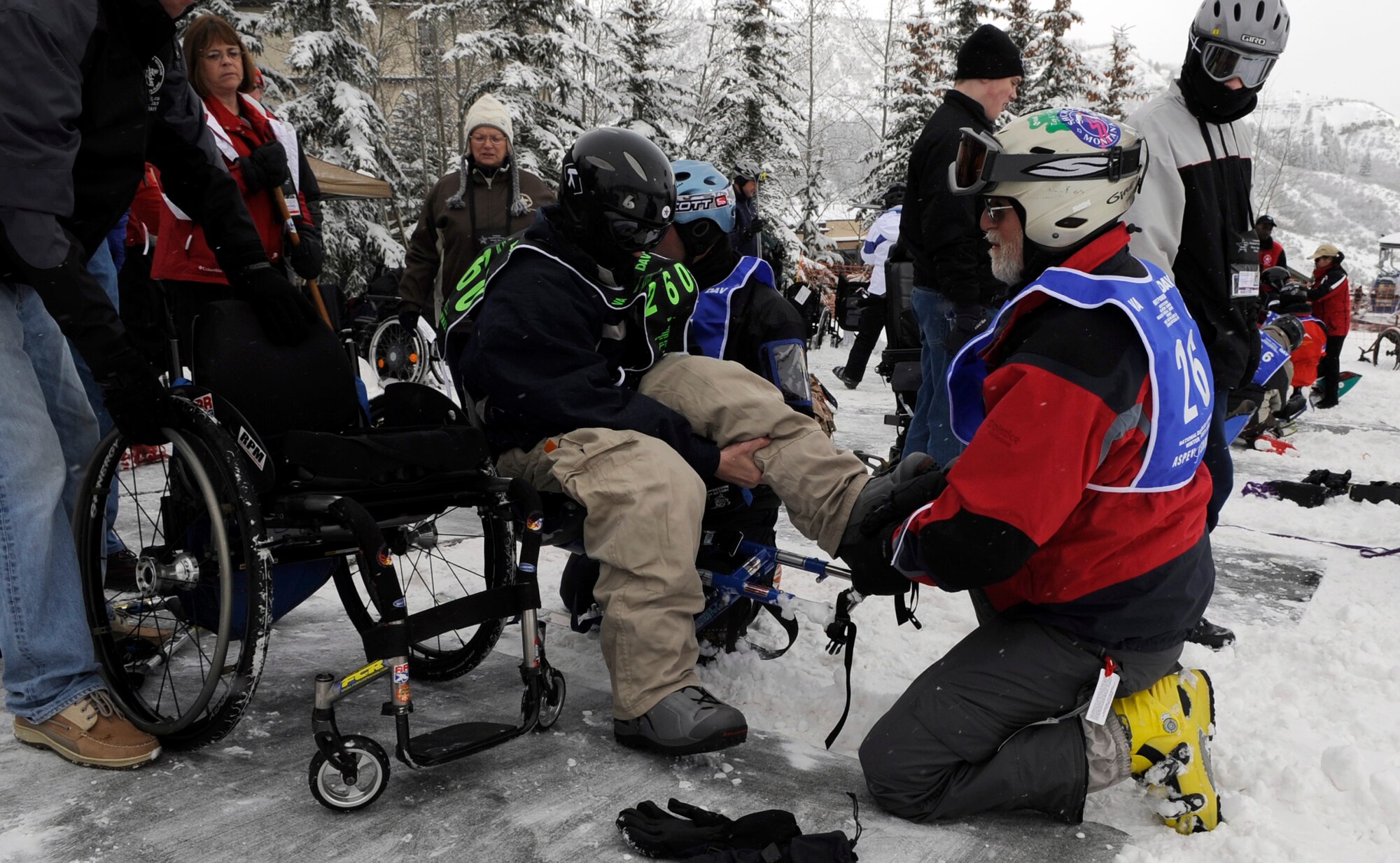 Senior Airman Shawn O'Neil exchanges his wheelchair for his turn to mono-ski with the help of an instructor during the 23rd National Disabled Veterans Winter Sports Clinic held March 30 at the Snowmass Village, Colo. (U.S. Air Force photo/Staff Sgt. Desiree N. Palacios)