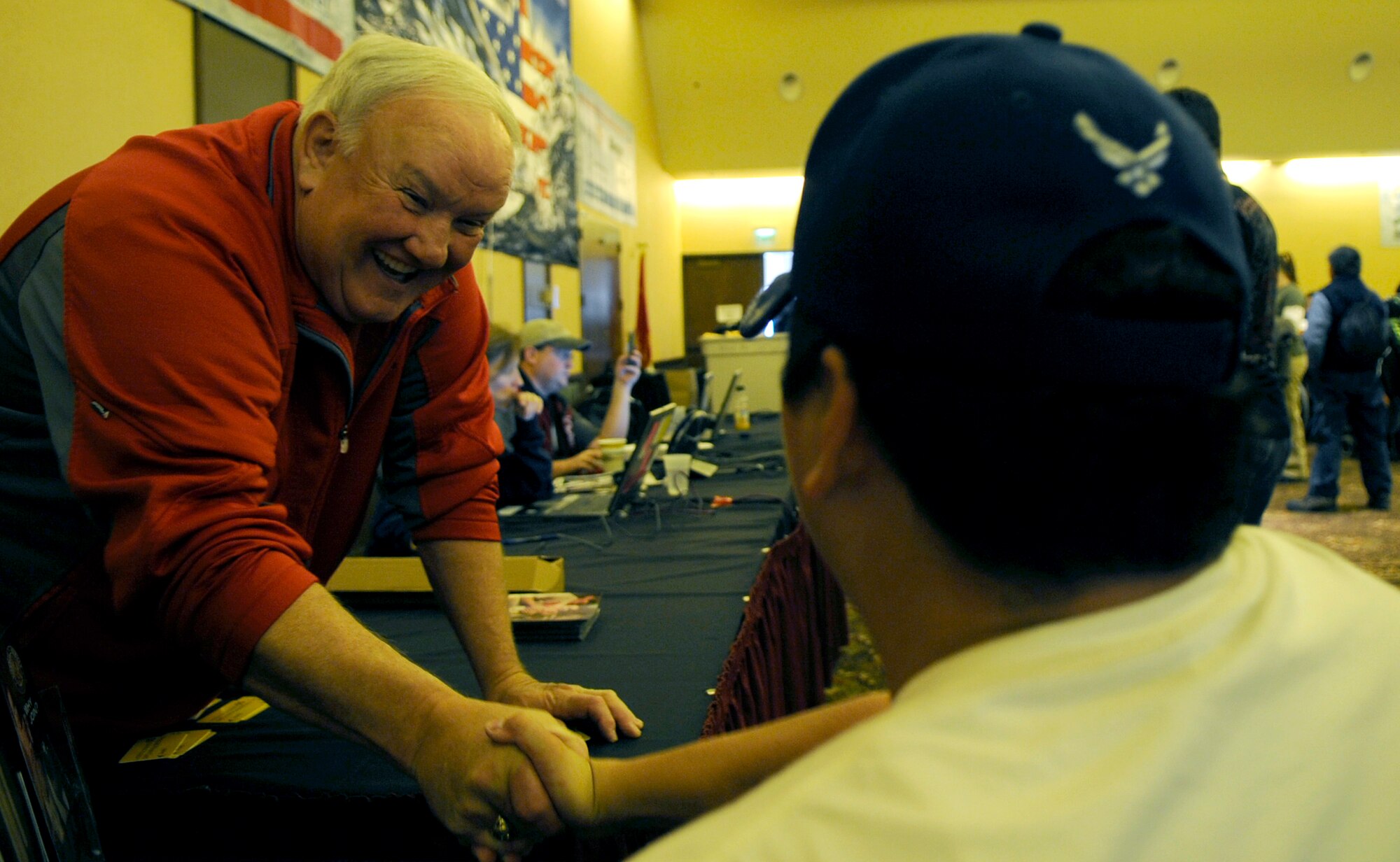 Senior Airman Kevin Krogh shakes hands with Larry Barnett inside The Silver Tree Hotel March 29 during registration for the 23rd National Disabled American Veterans Winter Sports Clinic in Snowmass Village, Colo. Airman Krogh lost both legs in a major car accident in 2007 and this will be his first year attending the sports clinic. Airman Krogh is assigned to Fort Sam Houston in San Antonio. Mr. Barnett is a former umpire in Major League Baseball. (U.S. Air Force photo/Staff Sgt. Desiree N. Palacios)

