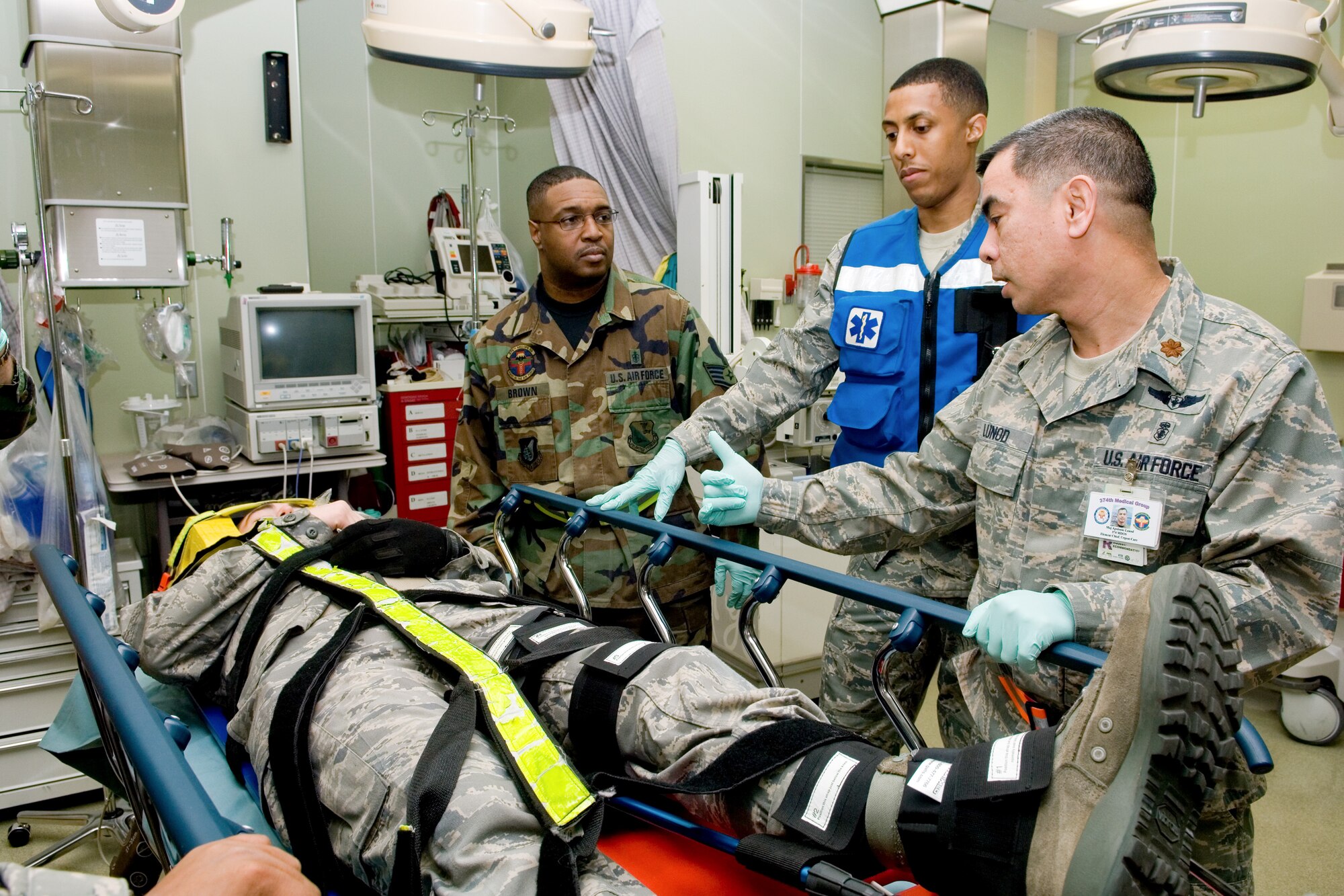 YOKOTA AIR BASE, Japan -- Major Apolonio Lunod, 374th Medical Operations Squadron, evaluates a simulated spinal injury patient March 31 at the base Hospital during Phase I of Exercise Beverly Morning 09-03. Yokota is conducting an exercise March 30 through April 3 to maintain operational readiness. (U.S. Air Force photo/Osakabe Yasuo)