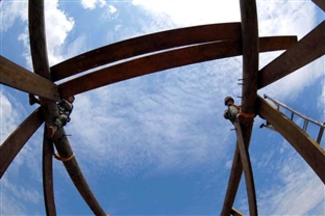 U.S. Navy Petty Officers 2nd Class Jared Quinn and Justin Rummel, both assigned to the Naval Mobile Construction Battalion 74, construct a timber tower during a training exercise on Camp Shelby, Miss., March 22, 2009. The construction battalion is conducting Operation Winter Talon, an exercise designed to test the battalions combat and contingency construction capabilities.