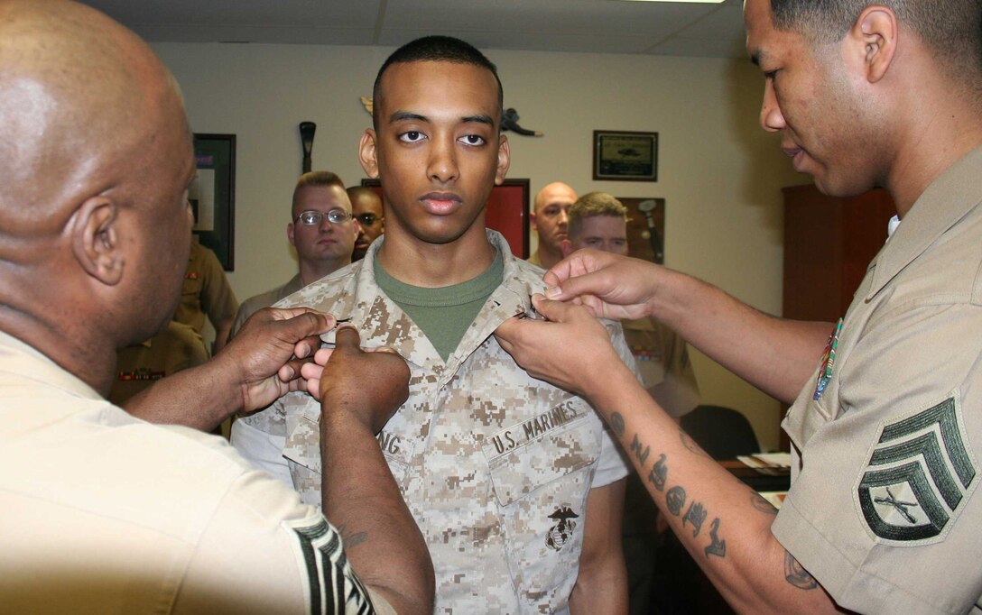 Sgt. Maj. Paul T. Archie, sergeant major of Recruiting Station Baltimore, and Staff Sgt. Alonzo Mountain, administration chief for RS Baltimore, help promote Justin Yawching, administration clerk for RS Baltimore, to corporal by pinning on his new rank May 1, at RS Baltimore.