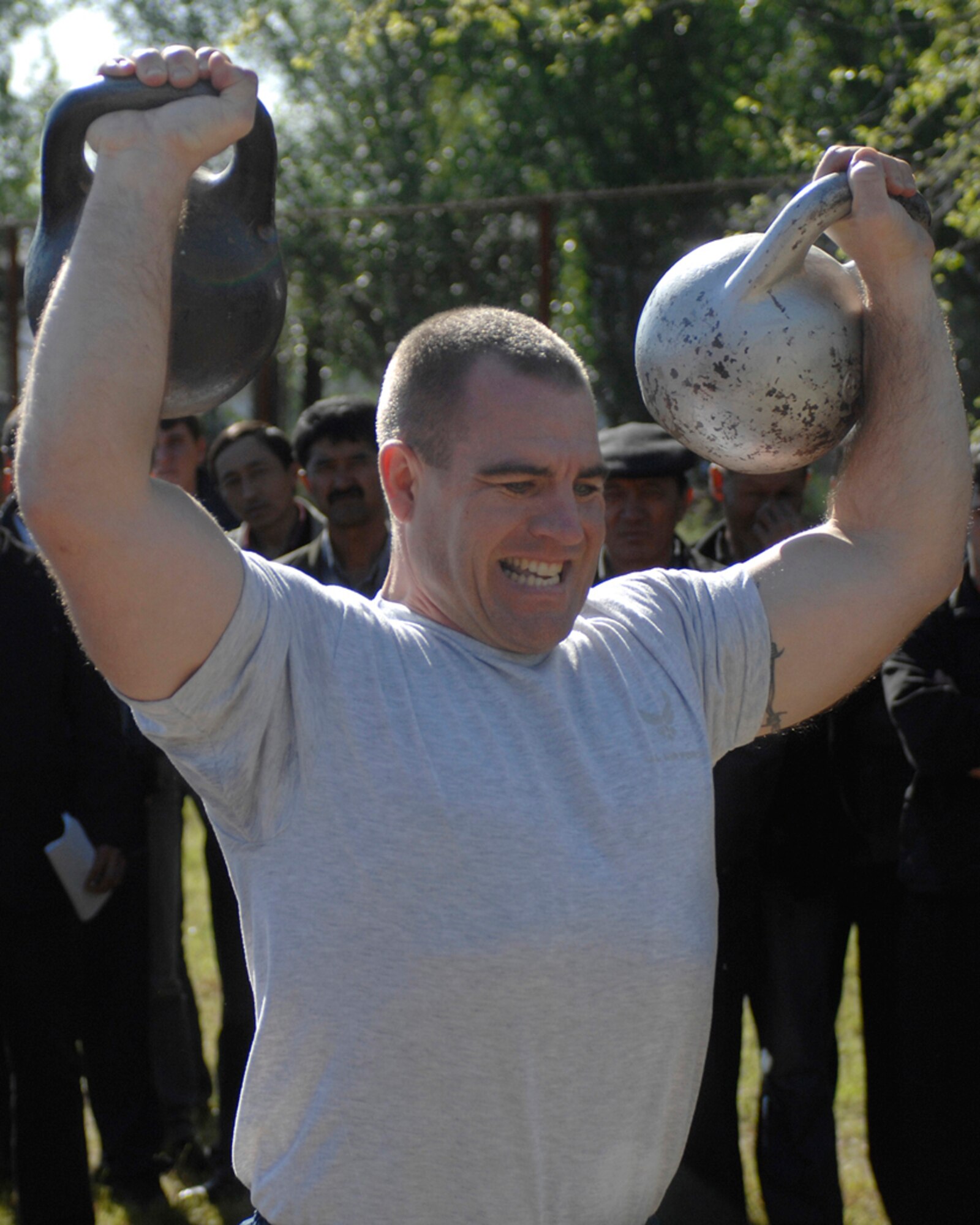 Master Sgt. William Hennis lifts two 55-pound kettle bells for 24 repetitions during the Manas International Airport Sports Day, April 30. Seageant Hennis is a weapons safety manager for the 376th Air Expeditionary Wing Safety Office at Manas Air Base, Kyrgyzstan, which is co-located at the airport. He is deployed from the 98th Range Wing, Nellis Air Force Base, Nev., and is a native of Cadiz, Ohio. (U.S. Air Force photo/Master Sgt. Charles M. Wade)
