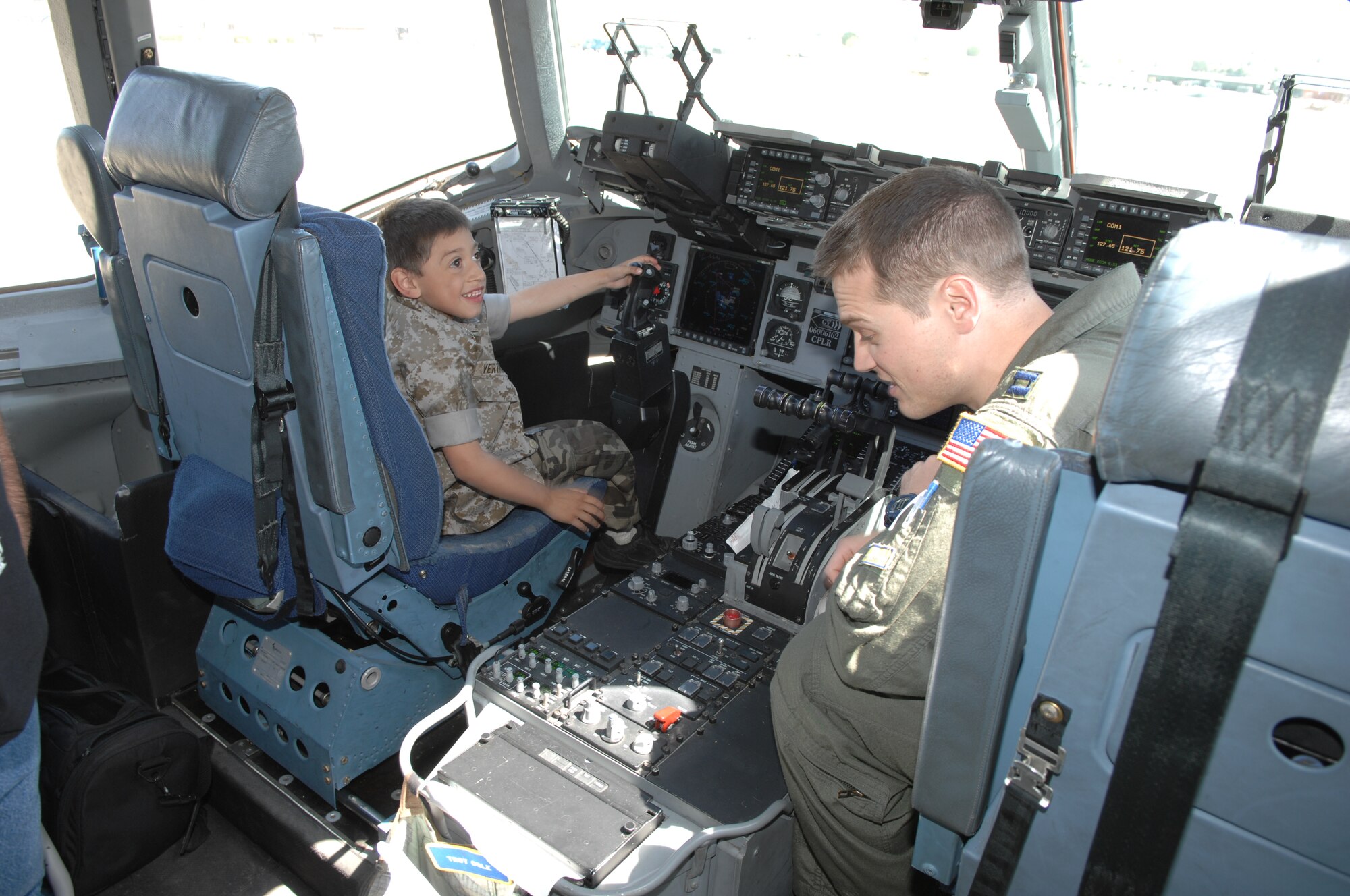 Andrew explores the cockpit of the C-17 with Captain Jonathan Askins from the 729th Airlift Squadron. (U.S. Air Force photo by Staff Sgt. Angel Gallardo)