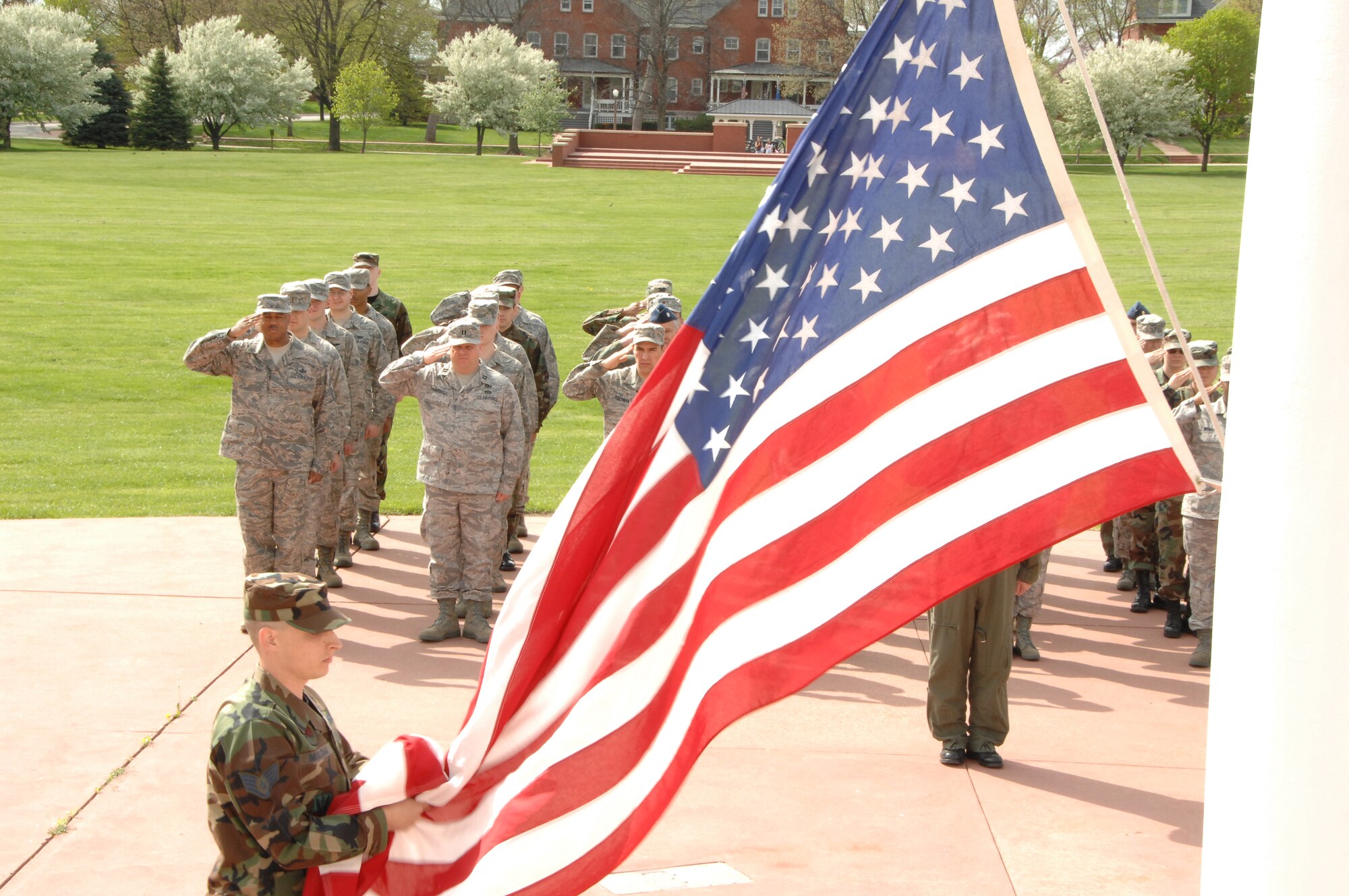 OFFUTT AIR FORCE BASE, Neb. - Members of the fighting 55th pay respect to the flag during a Retreat ceremony at the parade grounds here April 30. Retreat is an official ceremony which signifies the end of the duty day. U.S. Air Force photo by Dana Heard.