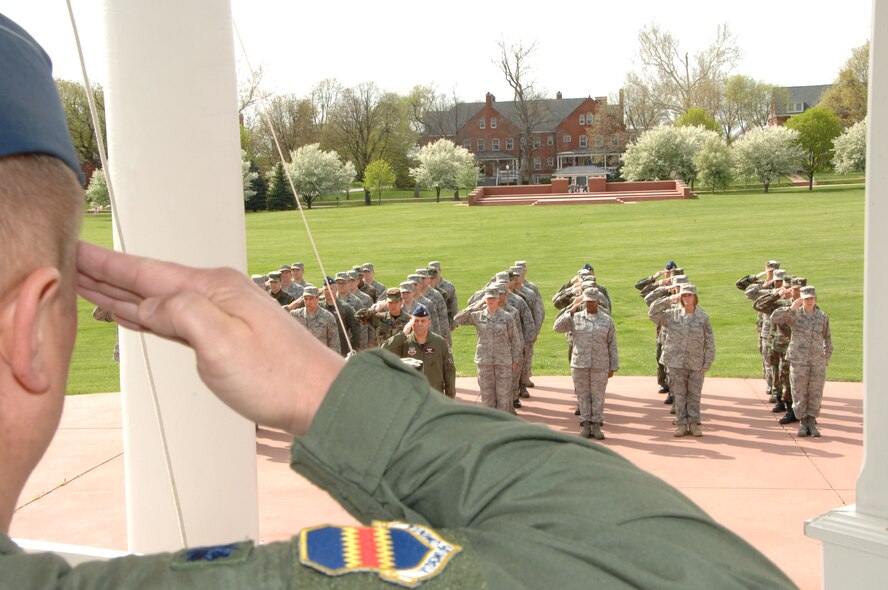OFFUTT AIR FORCE BASE, Neb. - Members of the fighting 55th pay respect to the flag during a Retreat ceremony at the parade grounds here April 30. Retreat is an official ceremony which signifies the end of the duty day.