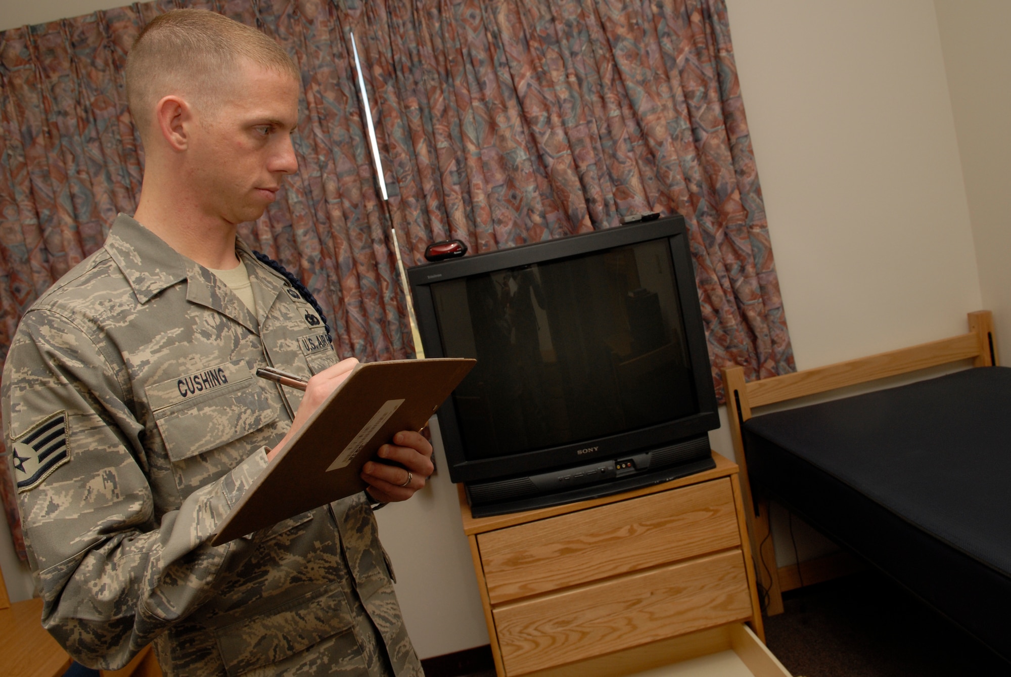 VANDENBERG AIR FORCE BASE, Calif. -- To ensure cleanliness and attention to detail, Staff Sgt. Ryan Cushing, a 381st Training Support Squadron military training leader, performs a room inspection May 1. MTL's counsel, mentor and train non-prior service technical training Airmen to adapt to military life at their next duty station. (U.S. Air Force photo/Senior Airman Christian Thomas)
