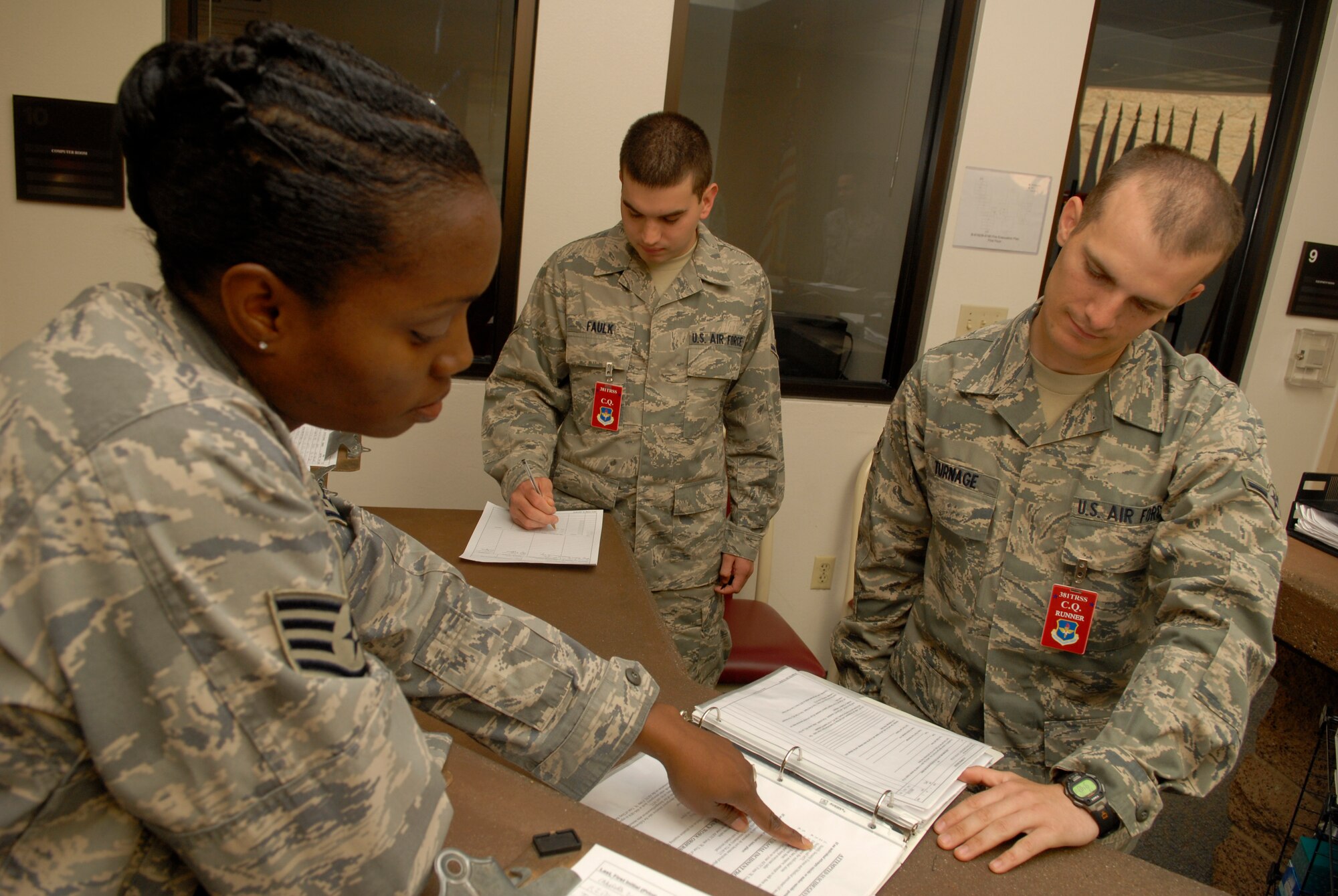 VANDENBERG AIR FORCE BASE, Calif. -- Before their shift starts, Staff Sgt. Jerilyn Watson, a 381st Training Support Squadron military training leader, goes over the charge of quarters duties with Airman Brandon Turnage, a 533rd Training Squadron student, while Airman James Faulk, also a student, takes notes May 1. MTL's counsel, mentor and train non-prior service technical training Airmen to adapt to military life at their next duty station. (U.S. Air Force photo/Senior Airman Christian Thomas)