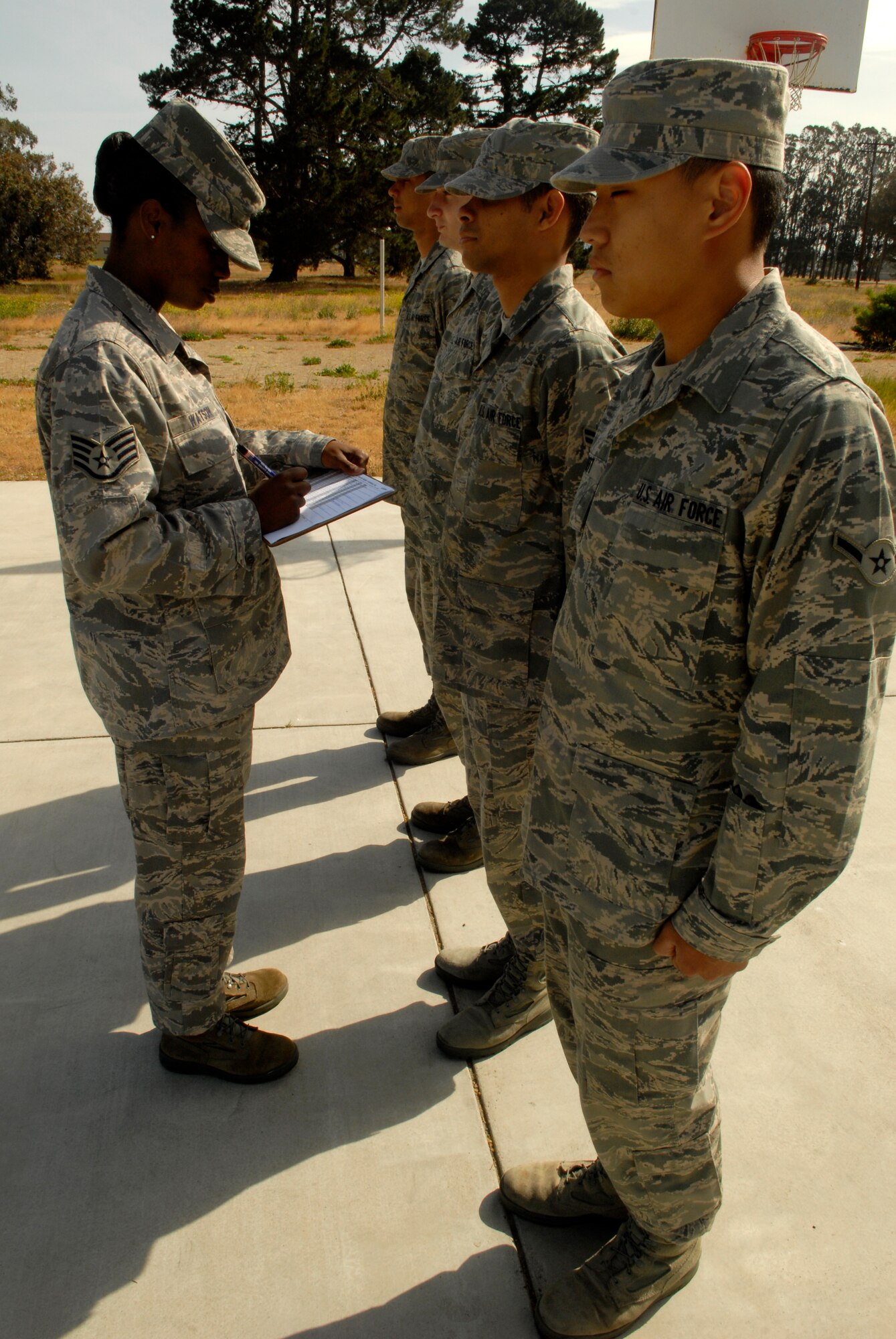 VANDENBERG AIR FORCE BASE, Calif. -- While Airmen stand at attention, Staff Sgt. Jerilyn Watson, a 381st Training Support Squadron military training leader, performs uniform checks during open ranks May 1. MTL's counsel, mentor and train non-prior service technical training Airmen to adapt to military life at their next duty station. (U.S. Air Force photo/Senior Airman Christian Thomas)
