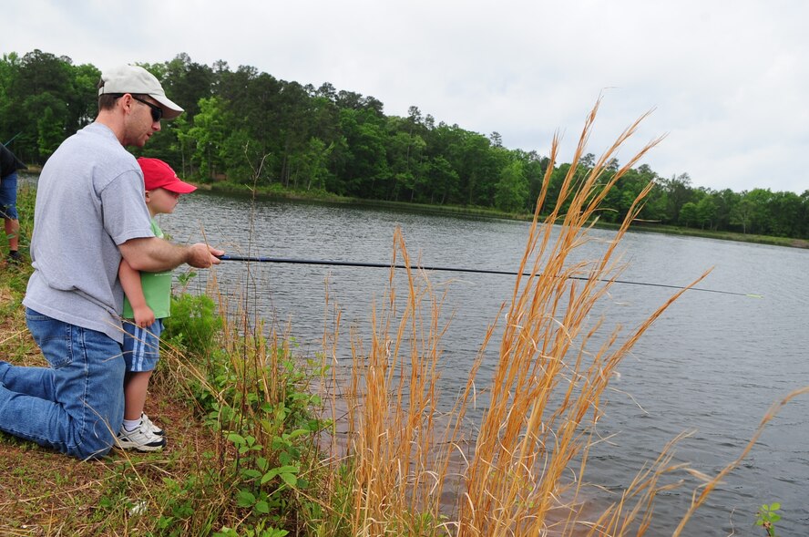 Maj. Kenn Cates, 2d Operations Support Squadron’s chief of wing scheduling, teaches his son Parker, 3, how to fish during the kid fish event held April 25. Major Cates was one of many parents who spent the day teaching their child to fish for the first time. (U.S. Air Force photo by Senior Airman Joanna M. Kresge)