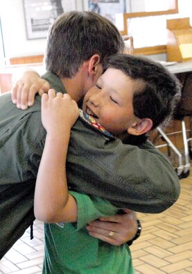 Christian Simmons, a former Luke Air Force Base pilot-for-a-day, and Maj. Sean Holahan, 62nd Fighter Squadron assistant director of operations, hug after being reunited two years after Simmons’ initial visit to Luke in 2007 as a pilot-for-a-day. (U.S. Air Force photo/ Deborah Silliman Wolfe.)