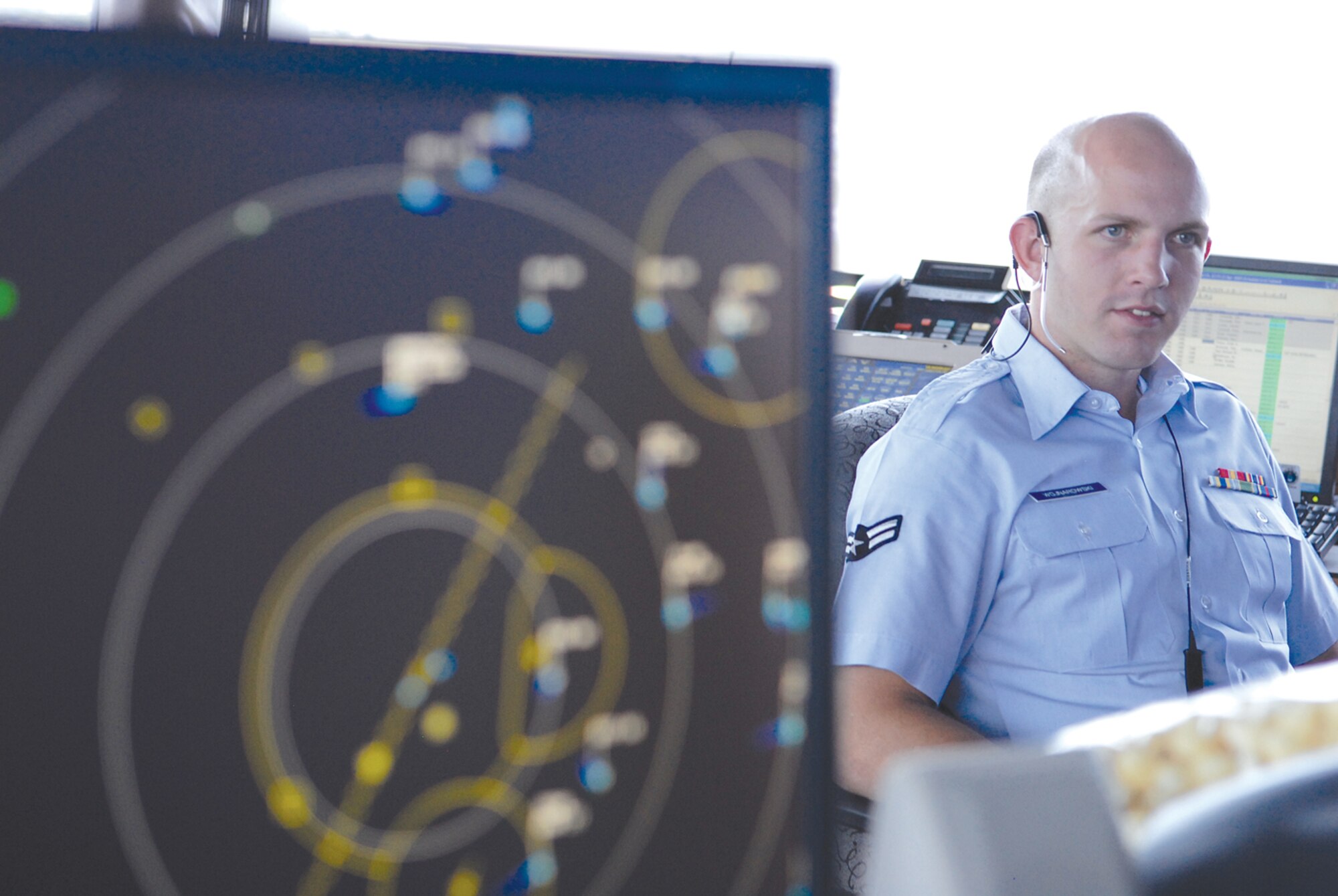 A radar tracks the movement of local aircraft as  Airman 1st Class Thomas Wojnaroski, 56th Operations Support Squadron air traffic control apprentice, collaborates with co-workers. (U.S. Air Force photo/ Deborah Silliman Wolfe.)