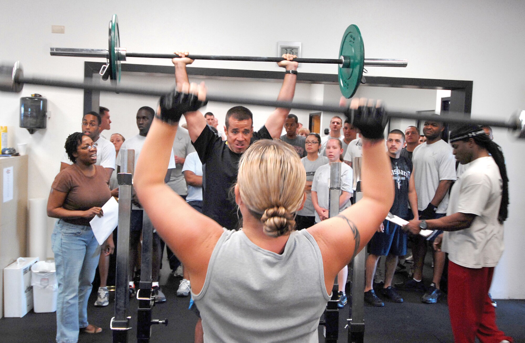 Maj. Jason Hokaj, 56th Fighter Wing flying executive officer, and Tech. Sgt. Lynette Castillo, 56th Fighter Wing command chief assistant, perform overhead presses during the CrossFit Challenge pitting the 56th Logistics Readiness Squadron against the 56th Fighter Wing staff agencies. (U.S. Air Force photo/ Tech. Sgt. Jeffery Wolfe.)