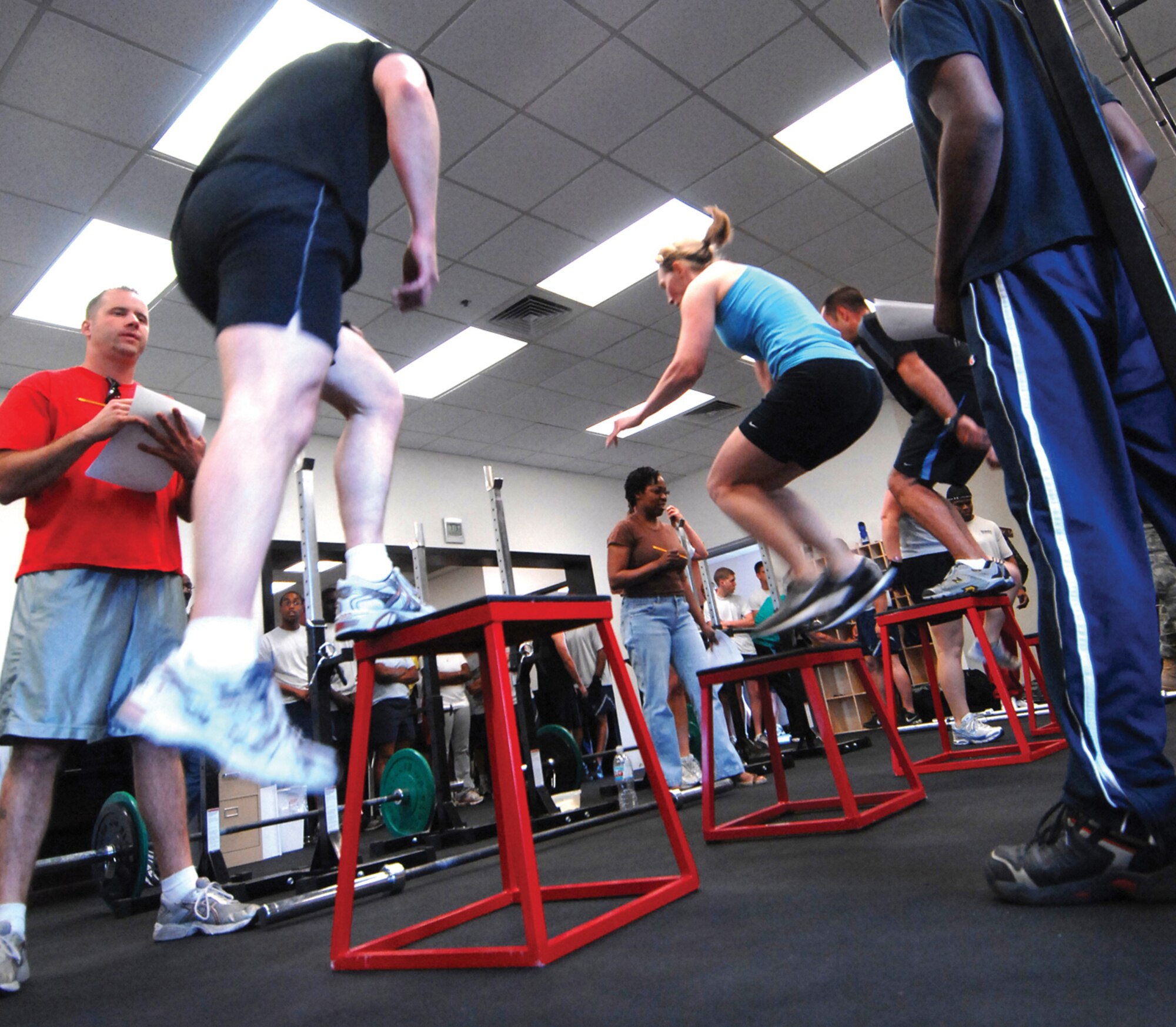 Competitors perform the “box jump” portion of the CrossFit Challenge. The CrossFit program attempts to be as inclusive as possible, gearing its flexible regimen to be accessible to everyone from elite athletes to homemakers. (U.S. Air Force photo/ Tech. Sgt. Jeffrey Wolfe.)