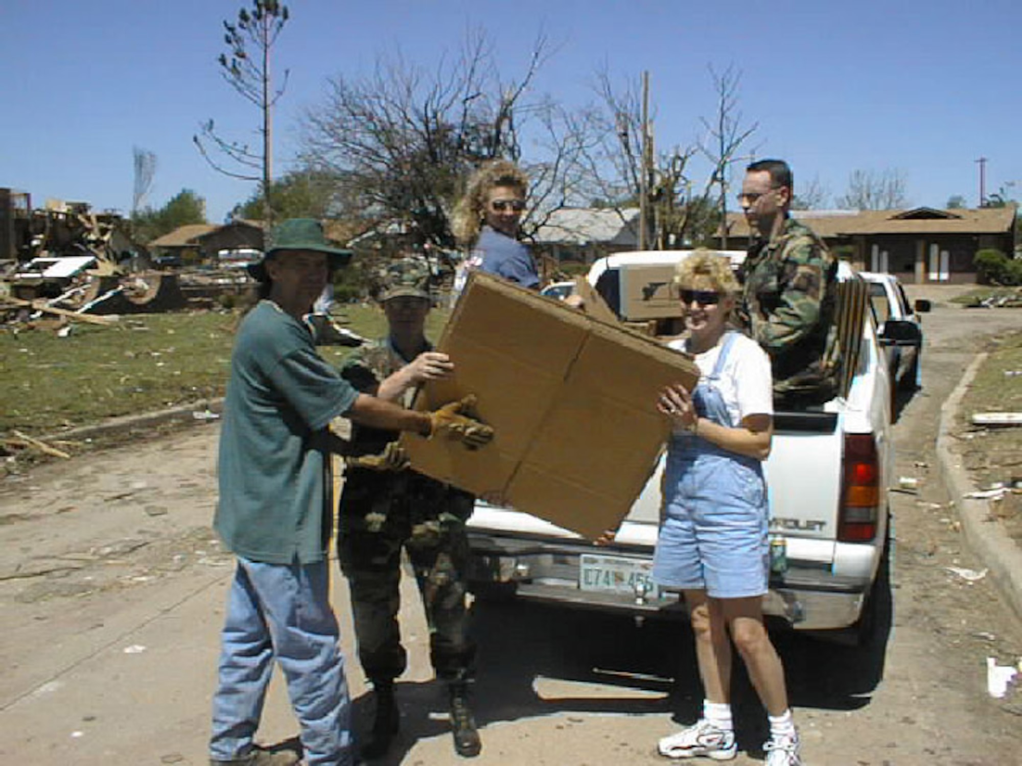 A local homeowner is given supplies by relief workers from Tinker Air Force Base and the Red Cross following the May 3, 1999 tornado.  Hundreds of loads of supplies were delivered throughout the neighborhoods bordering Tinker Air Force Base during tornado recovery work. (1999 file photo)