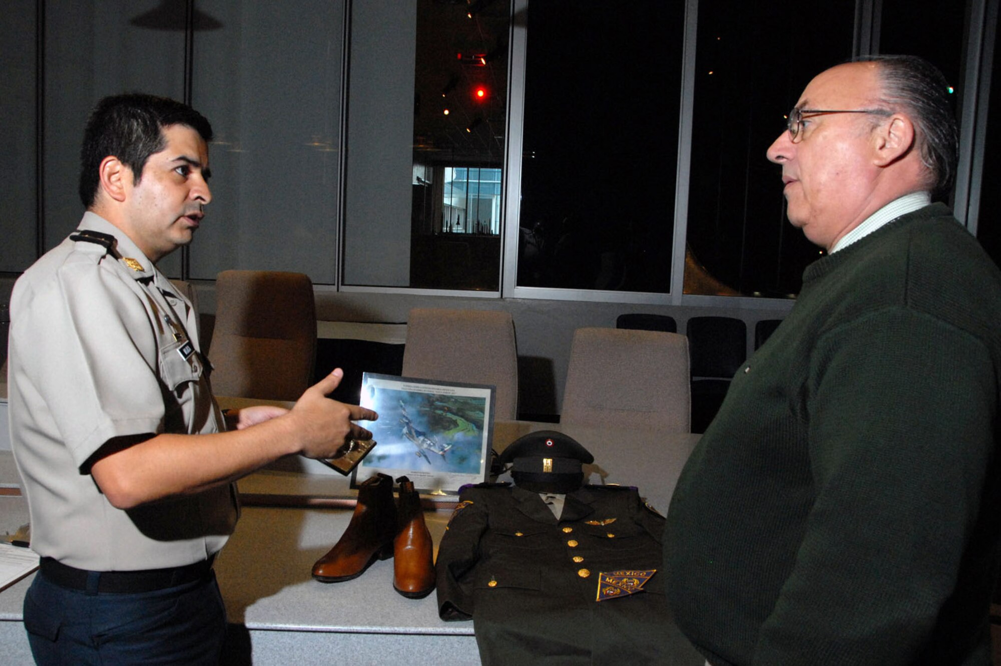 Mexican air force Lt. Col. Daniel Mojica gives information about some of the artifacts to Terry Aitken during a donation ceremony of Mexican air force items from World War II April 29 at the National Museum of the U.S. Air Force in Dayton, Ohio. Mr. Aitken is the senior curator for the museum. (U.S. Air Force photo) 

