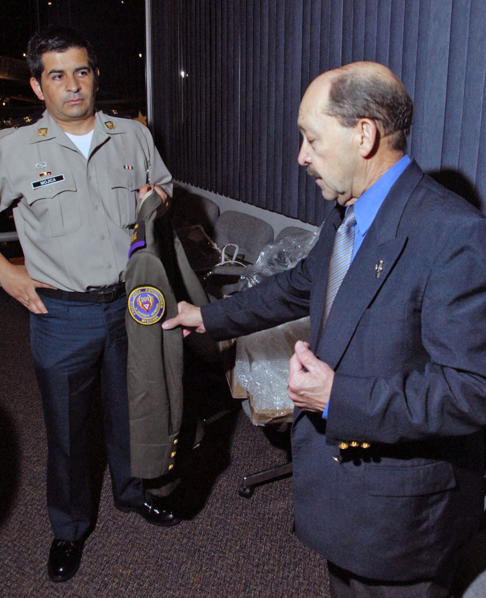 Retired U.S. Air Force Col. Rafael Ramos points to a patch on a Mexican air force uniform from World War II while Mexican air force Lt. Col. Daniel Mojica holds the uniform during a donation ceremony April 29 at the National Museum of the U.S. Air Force in Dayton, Ohio. (U.S. Air Force photo) 
