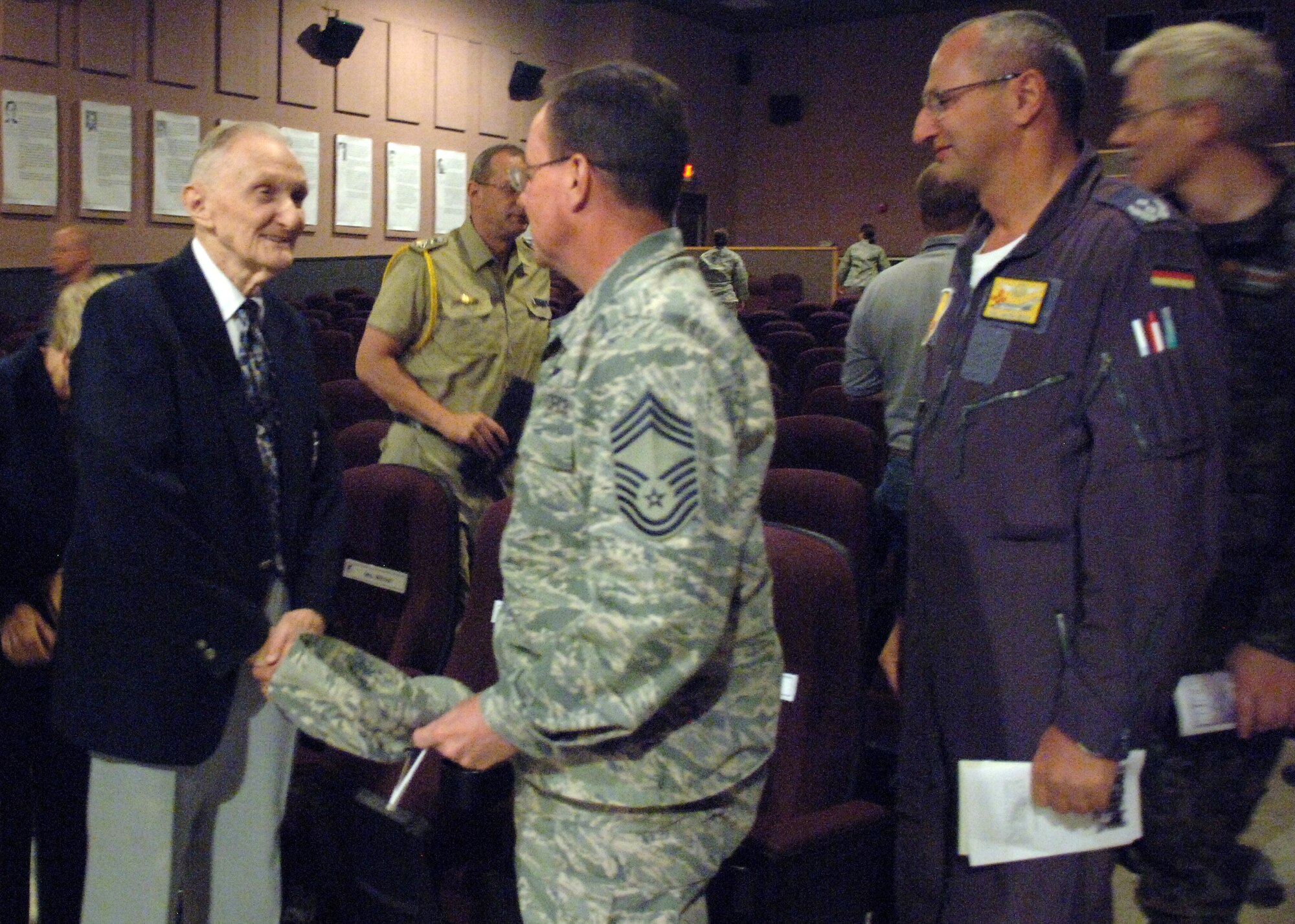 Chief Master Sergeant Kevin Blaney, 49th Operations Group superintendent, thanks Mr. Rolf A. Mitchel for his presentation during the Holocaust ‘Days of Remembrance’ at the base theatre on Holloman Air Force Base, N.M., April 21. The U.S. Air Force used the week of April 19-26 to remember the victims who endured the Holocaust. (U.S. Air Force photo/ Airman 1st Class Veronica Stamps)