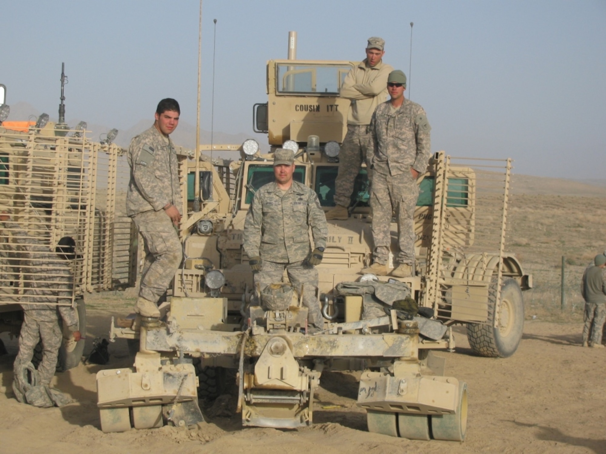 Senior Master Sgt. Kevin McRae stands with the mine roller and the crew after the truck was struck by an IED. Sergeant McRae traveled with the Route Clearance Package from the Kentucky National Guard as on scene support element. (Air Force photo) 