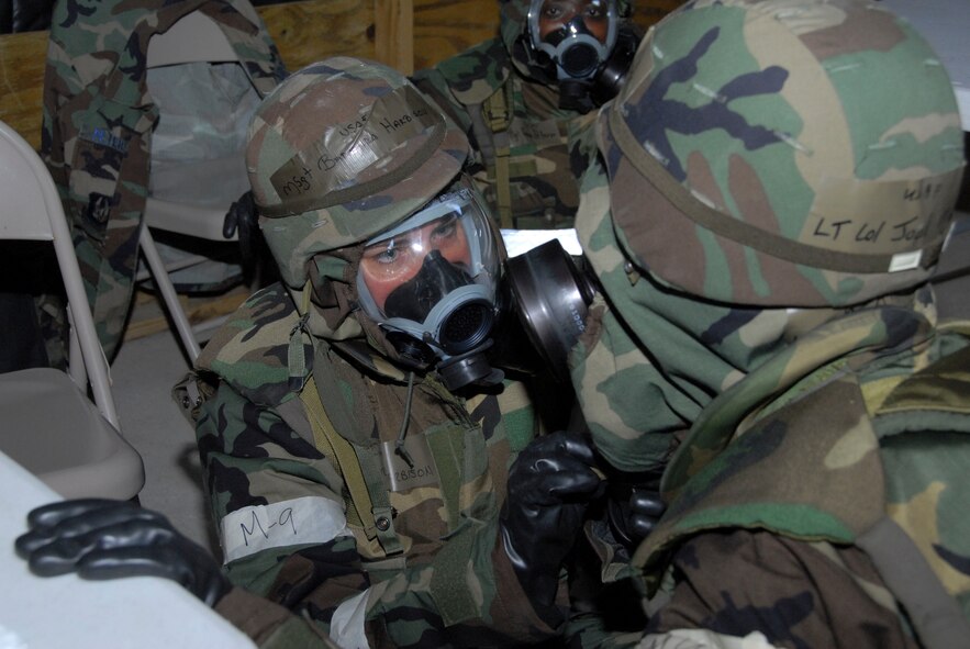 Master Sgt. Barbara Harbison, 908th Airlift Wing historian helps Lt. Col. Joel Marsh, 908th AW staff judge advocate with his gas mask Tuesday during a training exercise at Maxwell's training facility, Camp Blue Thunder. Members of the Reserve Wing are getting ready for an Operational Readiness Inspection as they conducted "Patriot Thunder" April 23-30. (U.S. Air Force photo by Jamie Pitcher)
