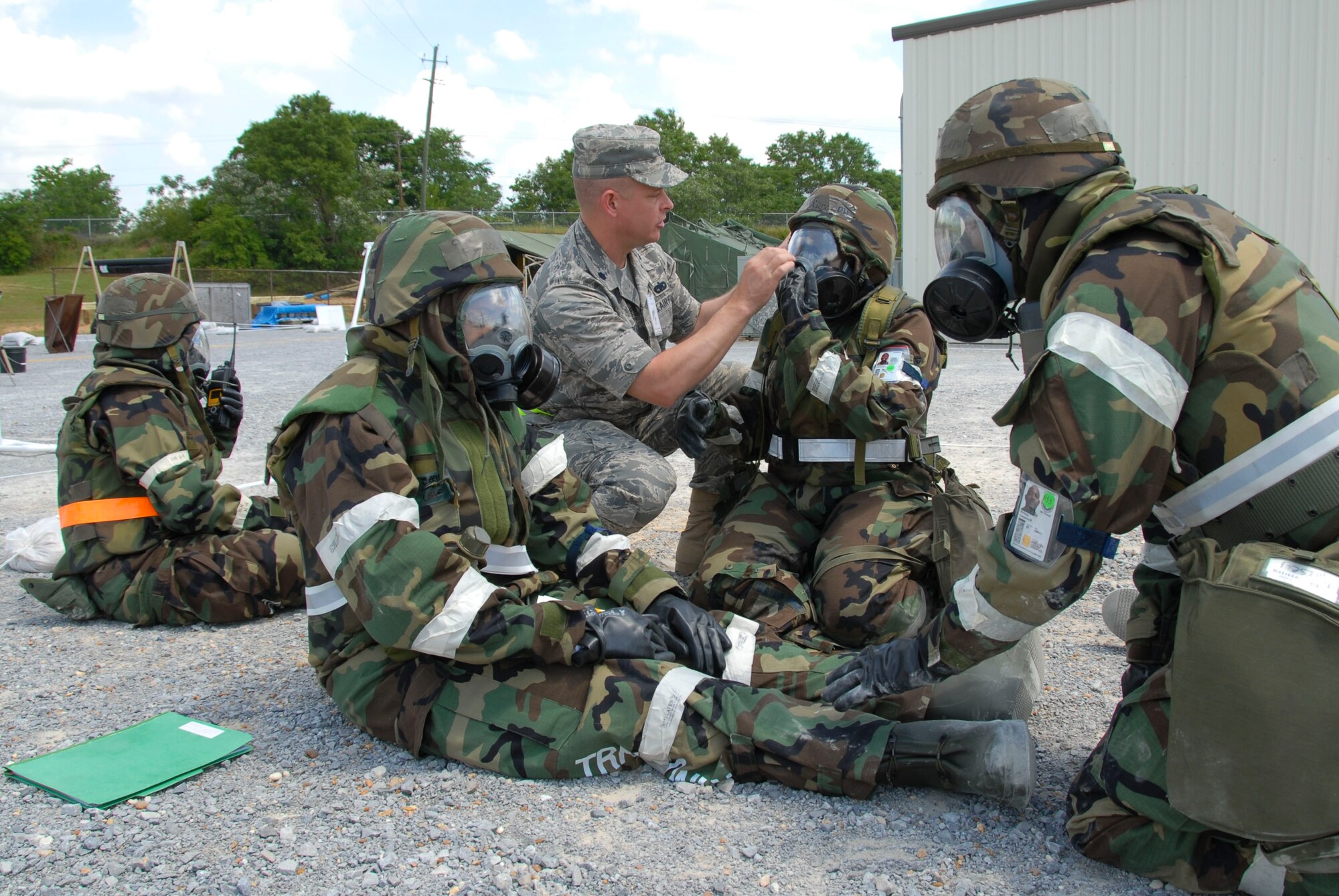 During a chemical attack, a member of the Exercise Evaluation Team checks seals on gas masks worn by exercise participants for possible leaks. (U.S. Air Force photo by Jamie Pitcher)