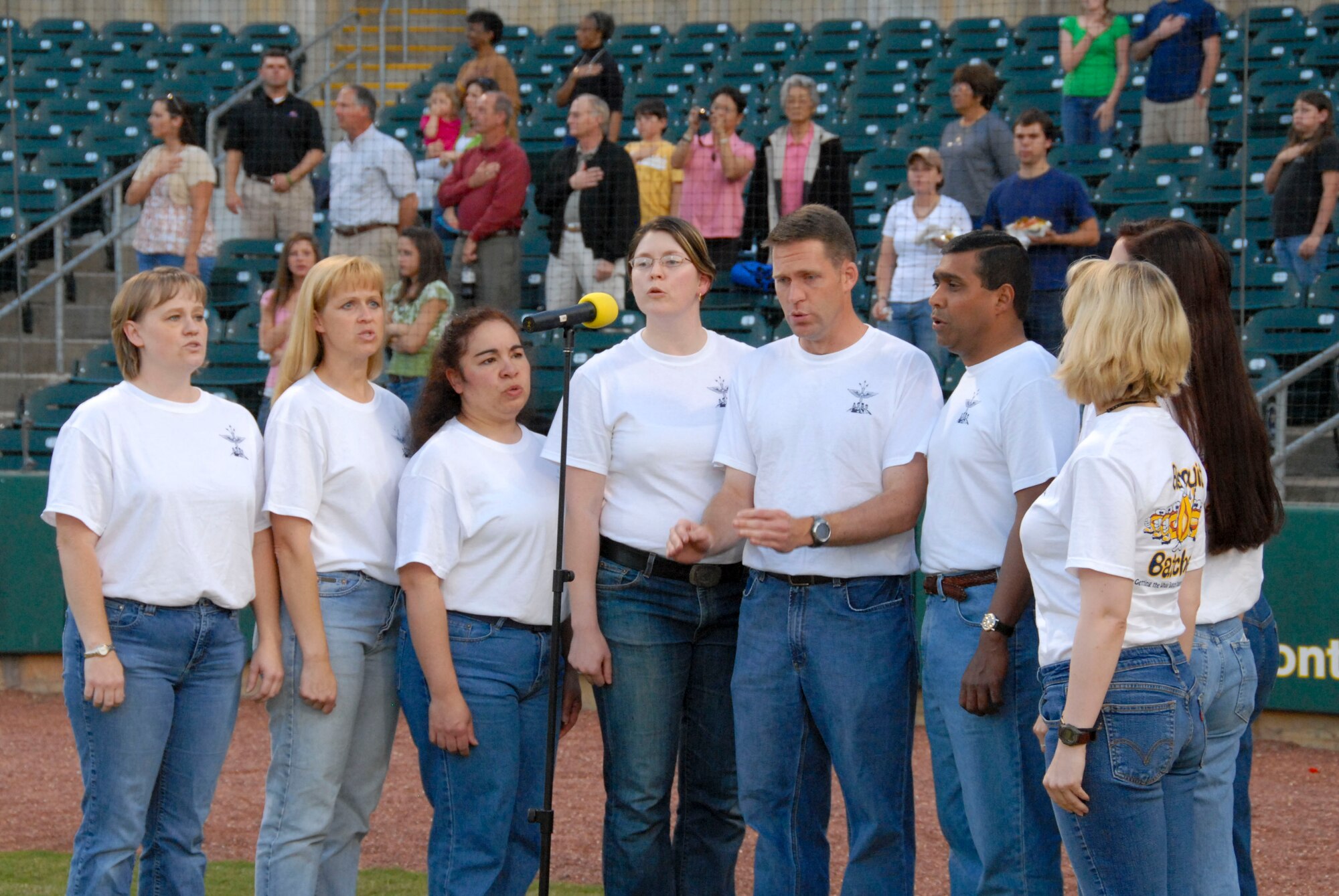 On the Montgomery Biscuits minor league baseball team’s first military discount night, April 22, at Riverfront Stadium, students from Air Command and Staff College had the opportunity to participate with opening festivities.  Shown singing the national anthem from left are Maj. Niki Kissiar, Maj. Ericka Flanigan, Maj. Estrella Rodgers, Maj. Melinda Moreau, Maj. David Hood, Group Capt. Andrew Wijesuriya of the Sri Lanka Air Force, Juanita Jasper, Maj. Ila Hahn, and Navy Lt. Cmdr. Shannon Callahan.  Throwing out the first pitches were dependents Greg Ogorek Jr., age 11, and Maddie Arnold, age 9. (U.S. Air Force photo by Jamie Pitcher)