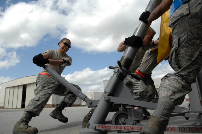 Senior Airman Michelle Metz and other maintenance technicians rotate a hydraulic jack here April 28. The 437th and 315th Maintenance Groups were recently awarded the Daedalian Trophy for best maintainers in the Air Force. Airman Metz is a crew chief with the 437th Aircraft Maintenance Squadron. 