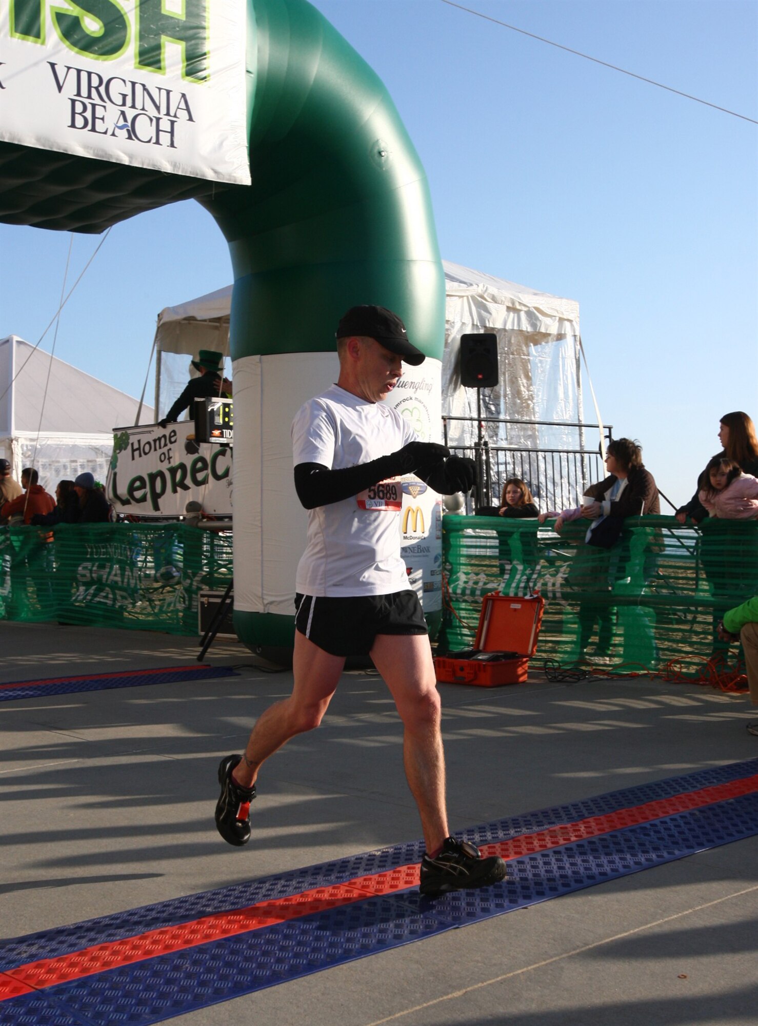 Master Sgt. James Richardson crosses the finish line and monitors his stopwatch for the time spent during the half Shamrock Marathon recently held in Norfolk, Va.  Sergeant Richardson, 65th SFS and 65th LRS first sergeant, is currently preparing to represent the United States Air Forces in Europe as the only delegate from Lajes in the upcoming 2009 Air Force Marathon. (U.S. Air Force courtesy photo)