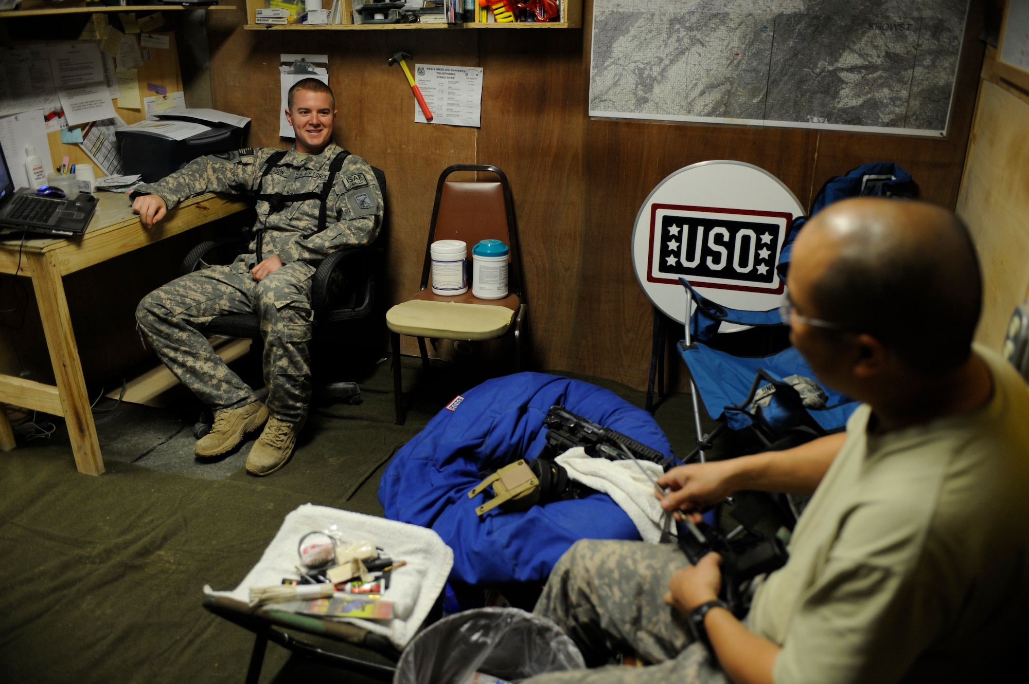U.S. Air Force Senior Airman Michael Davidson, medical technician, Paktya Provincial Reconstruction Team, talks to Tech. Sgt. John Tong, medical NCO in charge, as he cleans his weapon after participating in combat operations, April 14, 2009, Forward Operating Base Gardez, Afghanistan. (U.S. Air Force photo by Staff Sgt. Shawn Weismiller)