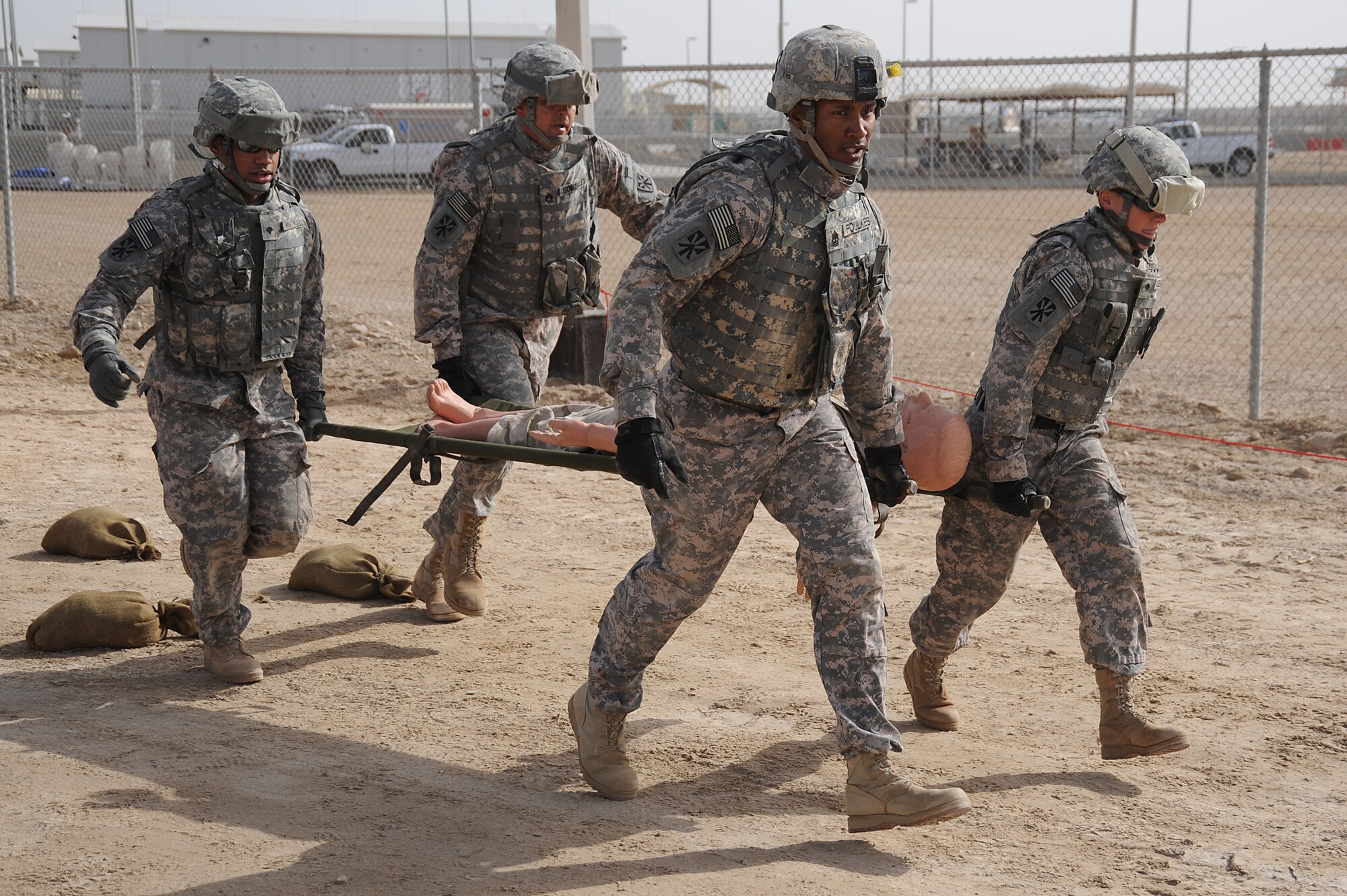 (Left to Right) Spc. Alexandre Whitnell, Staff Sgt. Patrick Gonzales, 1st Sgt. David Foulkes and Spc. Jennifer Stecher, 5-52 Air Defense Artillery Battalion, carry a "body" on a stretcher during a Defender Challenge course, April 25 at an undisclosed location in Southwest Asia. The team finished in second place, just one second behind the winning team. All four Soldiers are deployed with 5-52 Air Defense Artillery Battalion out of Fort Bliss, Texas. Specialist Whitnell hails from Chicago, Ill. Sergeant Gonzales is from El Paso, Texas. Sergeant Foulkes hails from Bronx, N.Y. Specialist Stecher is from Fredricksburg, Va. (U.S. Air Force photo by Senior Airman Brian J. Ellis) (Released)
