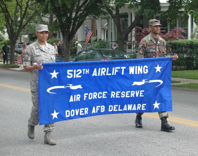 512th Airlift Wing members Senior Master Sgt. Rachael Gonesh and Senior Airman Devin Grace carry the Liberty Wing banner at the Old Dover Days parade May 2 in historic Dover, Del. Also in the parade was Col. Randal L. Bright, wife Amy, and their three children, Hayden, 8, Garrett, 6,  and Lauren, 1. The Liberty Belle, T-37 aircraft, was also featured in the parade. In it's 76th year, Old Dover Days offers a glimpse of the state capital and features a parade, maypole dancing, walking tours, entertainment, art, crafts and food. (U.S. Air Force photo/Capt. Marnee A.C. Losurdo)