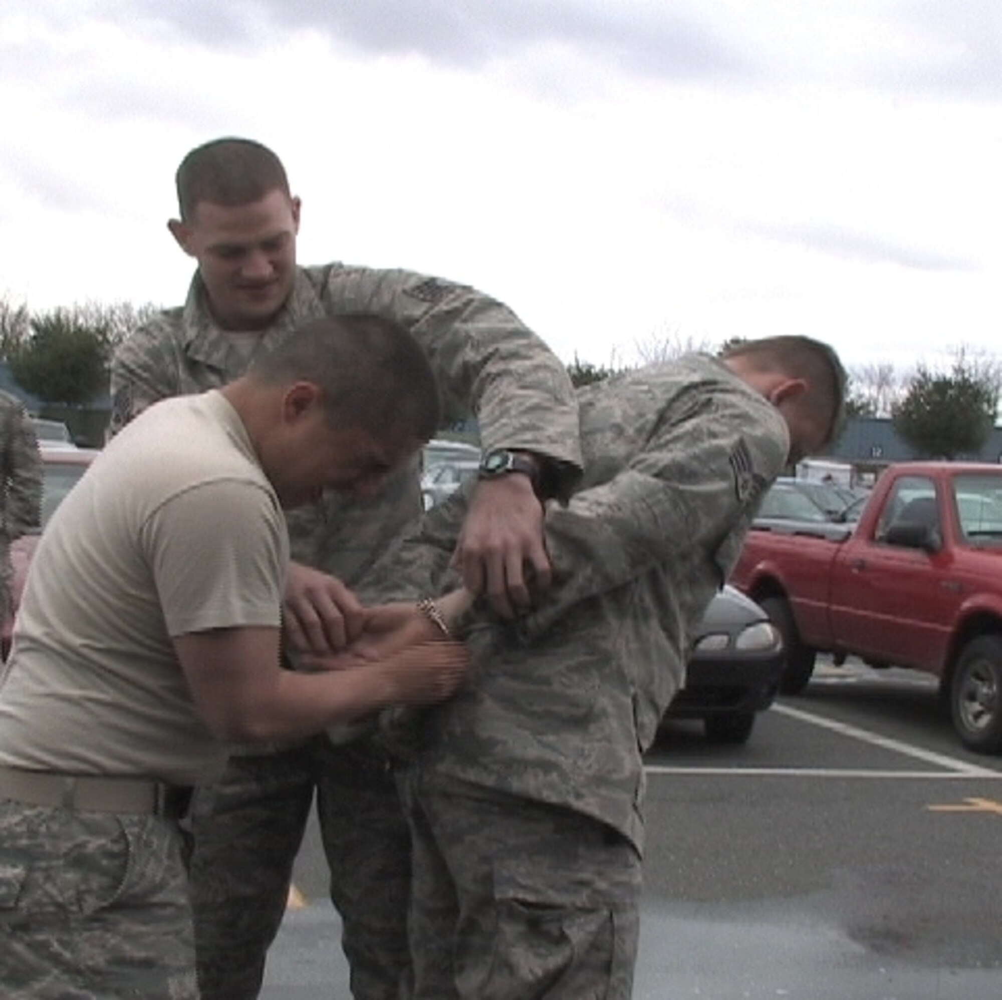 Senior Airman Cody Remy, security forces journeyman, 103rd Security Forces, cuffs fellow journeyman Senior Airman James Grala after being pepper-sprayed during an exercise on base April 4.  Staff Sgt. Brian Davies, CATM instructor, center, provides direction.  (U.S. Air Force image by Master Sgt. Michelle R. Thomas)  
