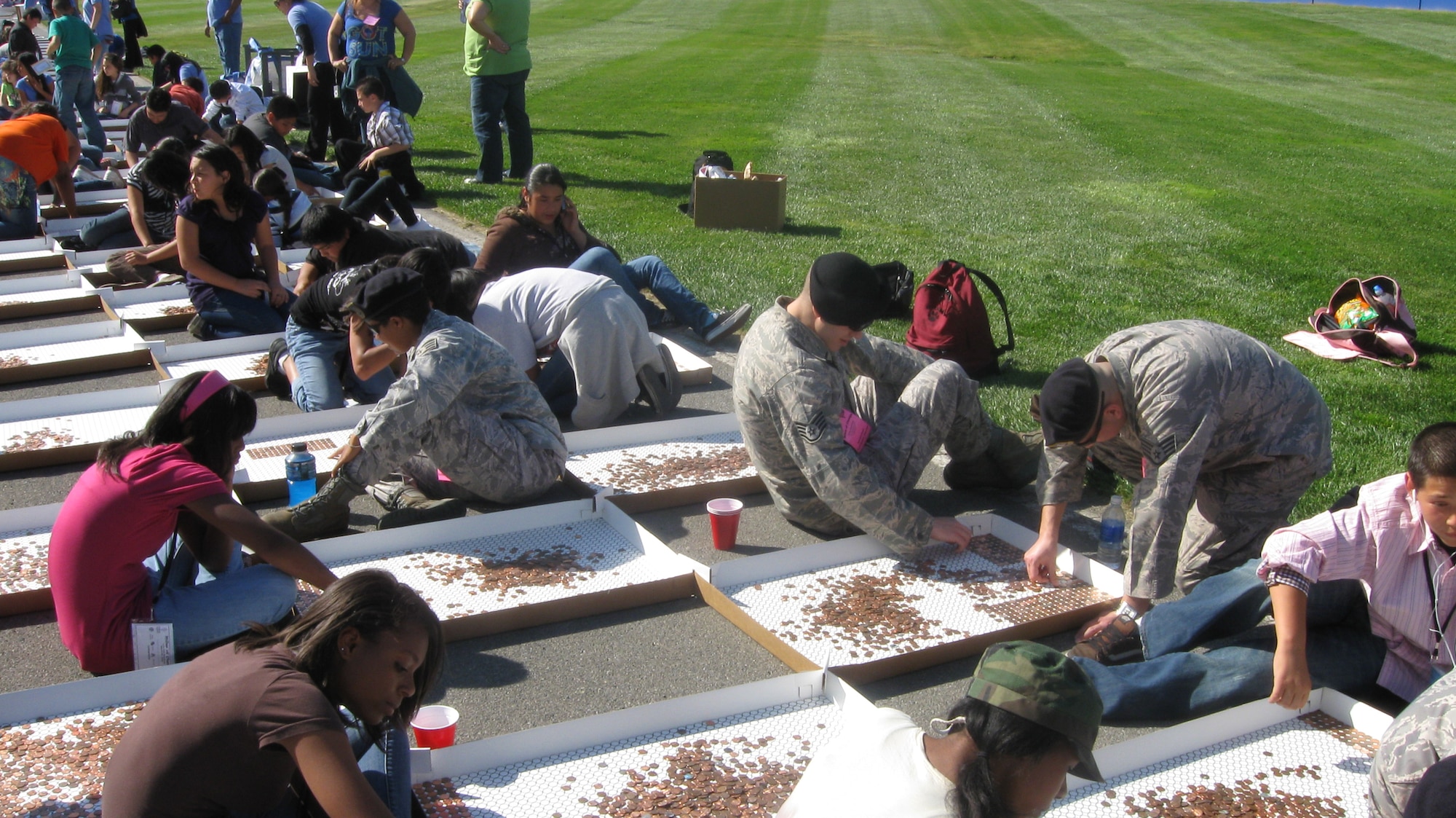 452d Security Forces Squadron members support Think Together’s “Miles of Change” event recently held at the Fontana Speedway. The event had a two-fold purpose; the first was to recognize the centennial of the penny and the second was to break the current record of 42 miles of pennies layed out. The world record was broken with 65 miles worth of pennies and the feat will be in the Guinness Book of World Records. Those in attendance from the 452nd SFS were Maj. John McDowell, Technical Sgt. David House, Technical Sgt. William Stephens, Staff Sgt. Heather Baptiste, Staff Sgt.
Giovanni Moscoso, Staff Sgt. Daniel White and Staff Sgt. Thomas Green. Think Together was founded as an organization to help kids who were struggling in school. It is an after school program that caters to students in Southern California. There were approximately 200 students on hand for the event. (U.S. Air Force courtesy photo)