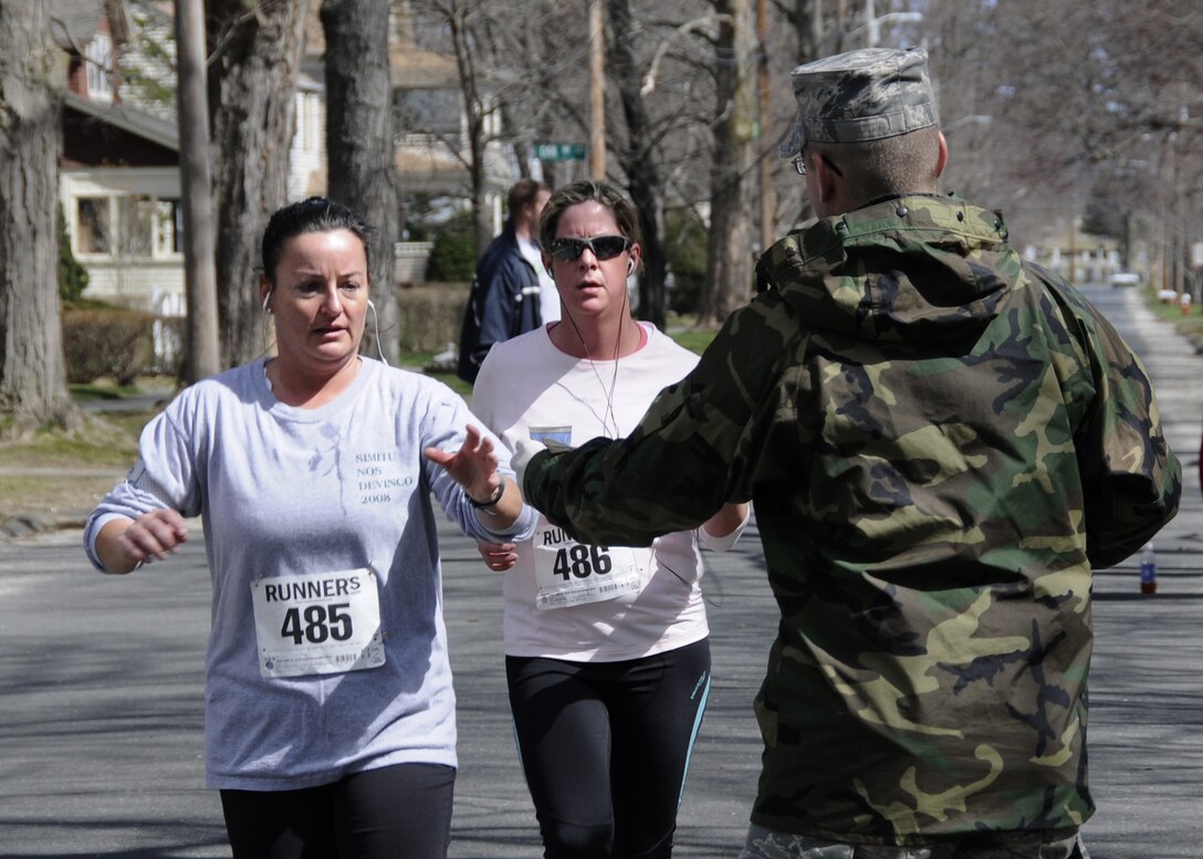 A1C Chad Hammon hands water to runners in the Oleksak Road Race.        