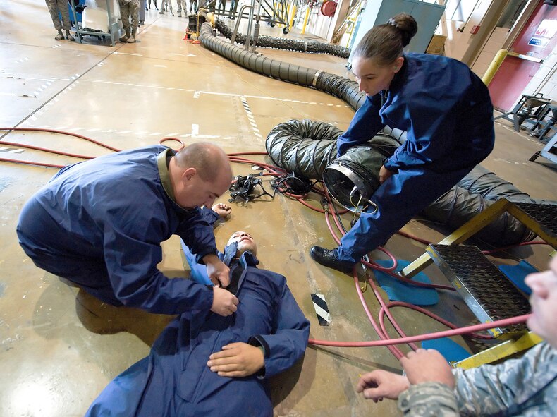 Tech. Sgt. Paul Spencer, 512th Maintenance Squadron fuel systems repair journeyman, and Senior Airman Sabrina Kibler, 512th MXS fuels systems apprentice, assist fellow squadron member Staff Sgt. Corey Barnes during an emergency evacuation exercise April 25. The Air Force Reserve Command Inspector General team evaluated maintenance members? ability to rescue personnel trapped in a confined space as one of the requirements for the 512th Airlift Wing?s Unit Compliance Inspection April 23-27.  (U.S. Air Force photo/Jason Minto) 