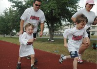 919th Special Operations Wing members and their families participated in the base fun run at Duke Field, May 2.  Tech. Sgt. Robert Breitenstein, 919th Maintenance Squadron, along with his sons Luke (left) and Logan (right), teamed up with Capt. Polly Orcutt, 919th Mission Support Group, for a run around the track. Participants completed their trips around the track stopping at stations along the way to attempt fun challenges like jumping rope, playing with a hula-hoop, and doing push-ups. (U.S. Air Force photo/Staff Sgt. Jon McCallum)