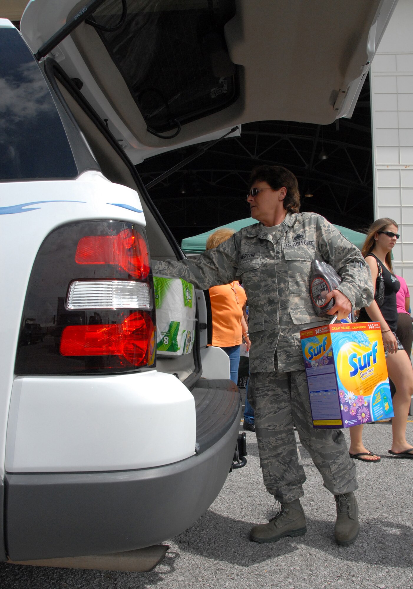 Senior Master Sgt. Theresa Morton, 919th Logistics Readiness Squadron, helps customers load up their cars after checking out at the case lot sale at Duke Field May 2.  People began lining up early, braved the heat of the day, and long wait to get the deals available from the sale.  U.S. Air Force photo/Staff Sgt. Samuel King Jr.