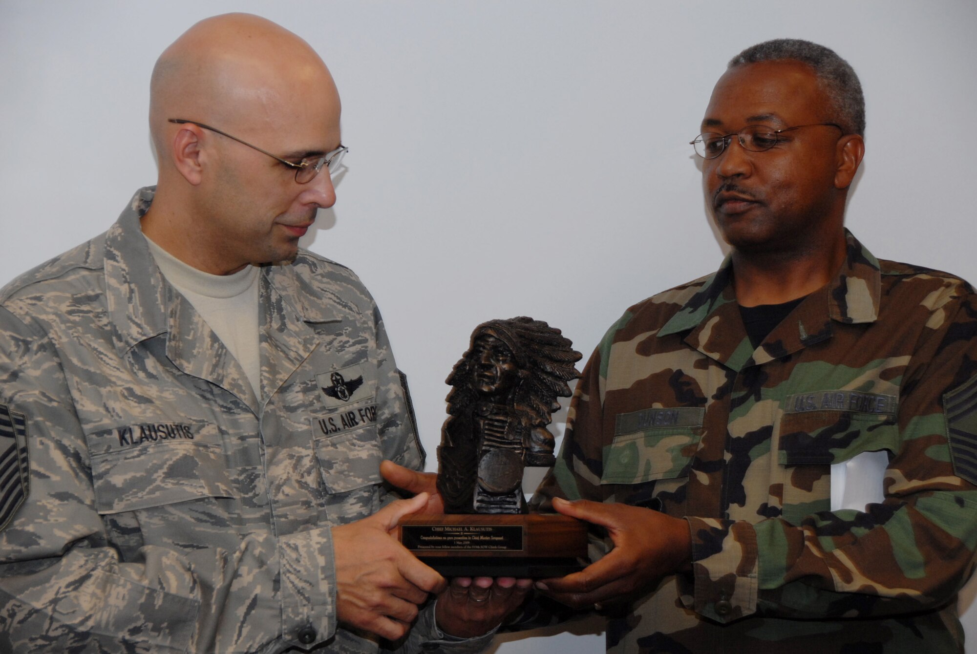 Chief Master Sgt. James Dunson 919th Logistics Readiness Squadron, passes the ceremonial chief bust newly promoted Chief Master Sgt. Michael Klausutis, the 919 Special Operations Wing’s newest chief master sergeant and command chief.  During the ceremony, the chief bust was passed from every chief within the wing before ending with its newest member.  U.S. Air Force photo/Staff Sgt. Samuel King Jr.