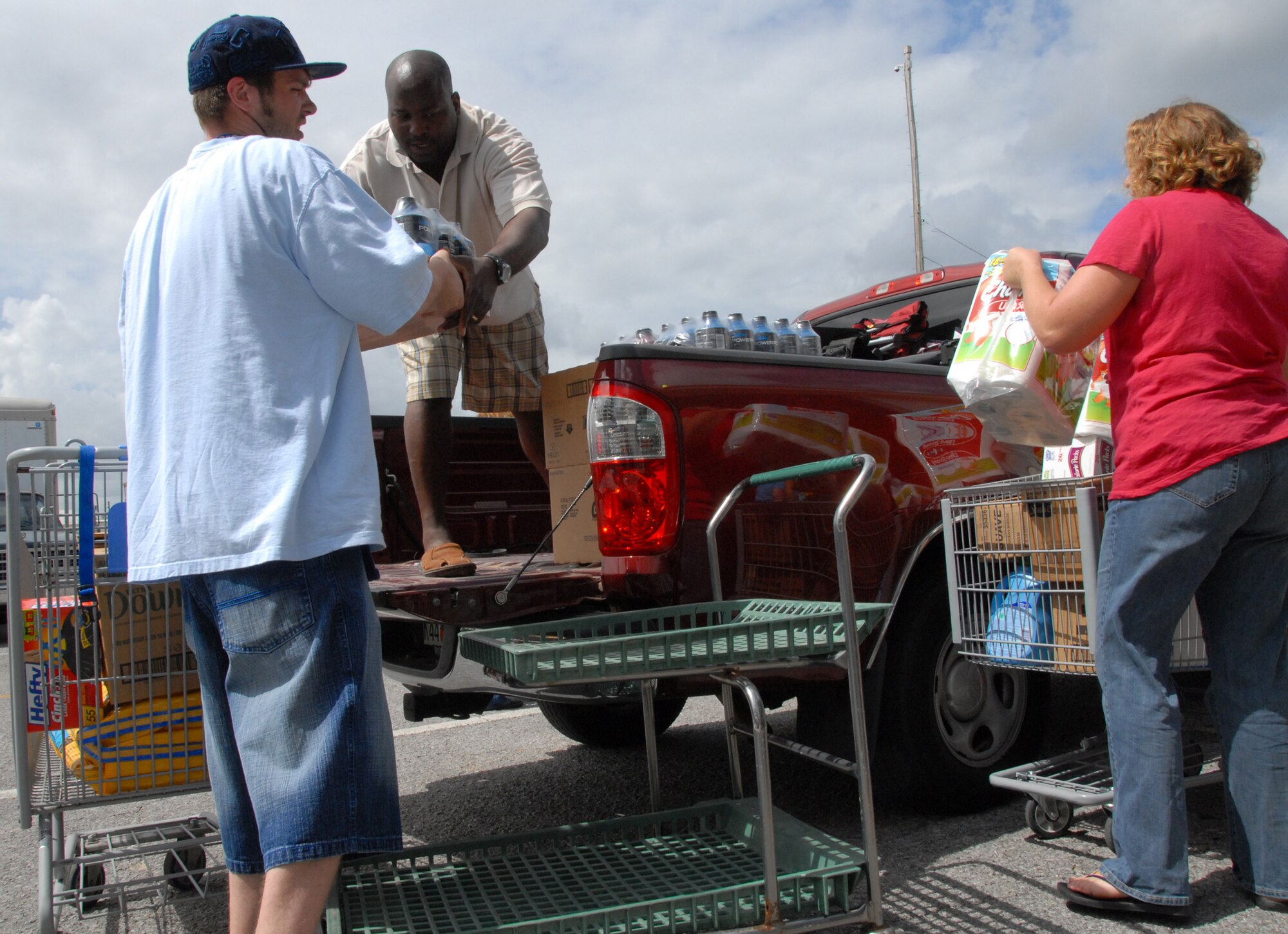 DECA employees help customers load up their truck during the case lot sale at Duke Field May 2.  People began lining up early, braved the heat of the day, and long wait to get the deals available from the sale.  U.S. Air Force photo/Staff Sgt. Samuel King Jr.