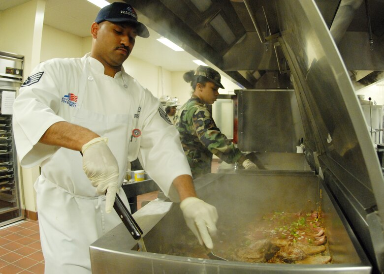 Staff Sgt. Chito Reyes, 919th Services Flight, flips pork chops while Senior Airman Brittnie Lewis stirs another vat in preparation for the lunch May 3 at the Duke Field dining facility.  The 919th SVF won a Hennessy Award this year for their superior performance at the dining facility.  U.S. Air Force photo/Staff Sgt. Samuel King Jr.