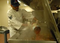 Staff Sgt. Chito Reyes, 919th Services Flight, pours tomatoes onto a vat of pork chops in preparation for the lunch May 3 at the Duke Field dining facility.  The 919th SVF won a Hennessy Award this year for their superior performance at the dining facility.  U.S. Air Force photo/Staff Sgt. Samuel King Jr.
