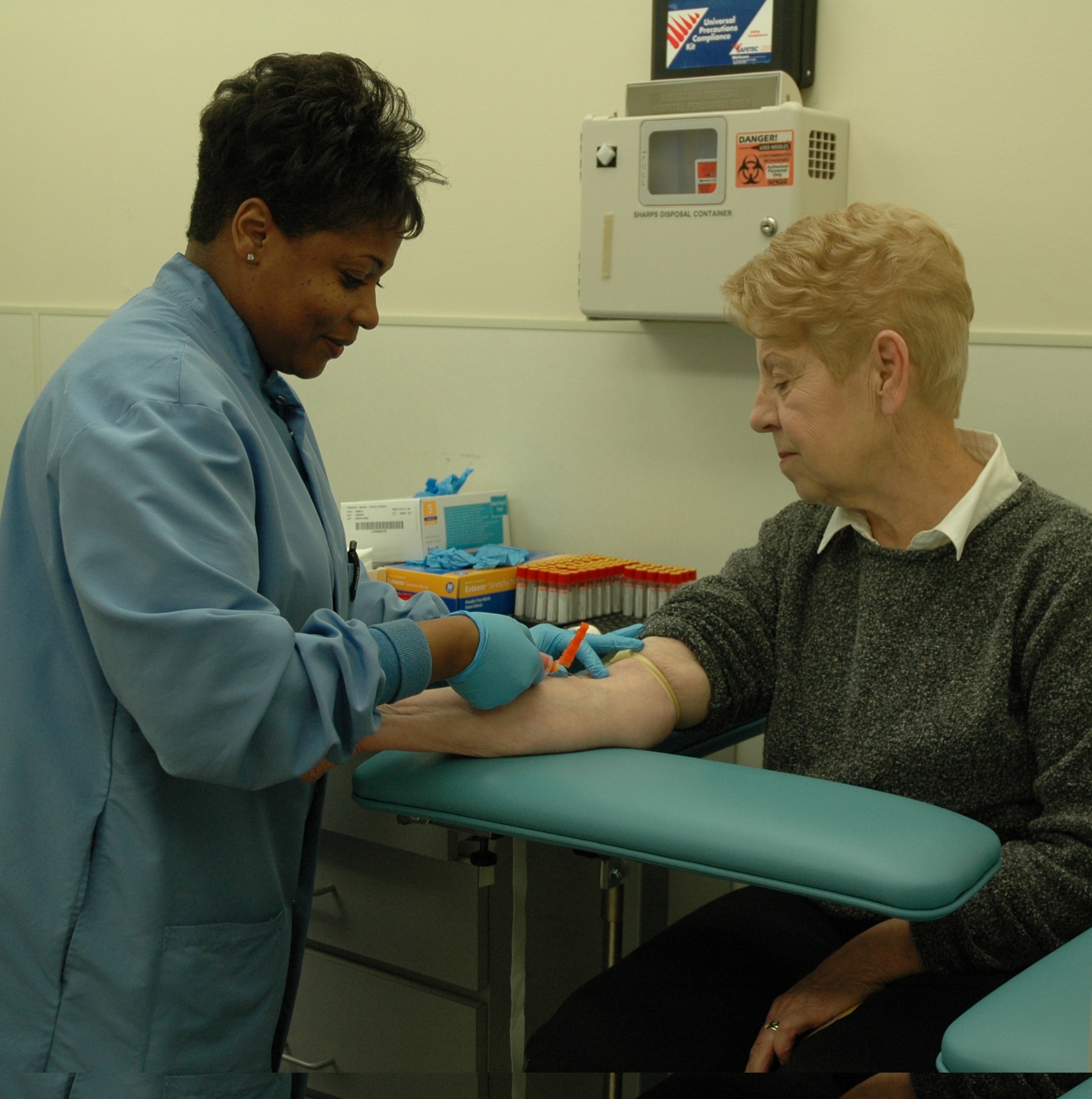 Tech. Sgt. Tiffany Sykes, assistant NCOIC of Laboratory Services, draws a blood sample from Marilyn Taylor April 25. Cholesterol screenings were offered to retirees during activities at the base clinic in their honor April 24-25. (U.S. Air Force photo/Valerie Mullett)