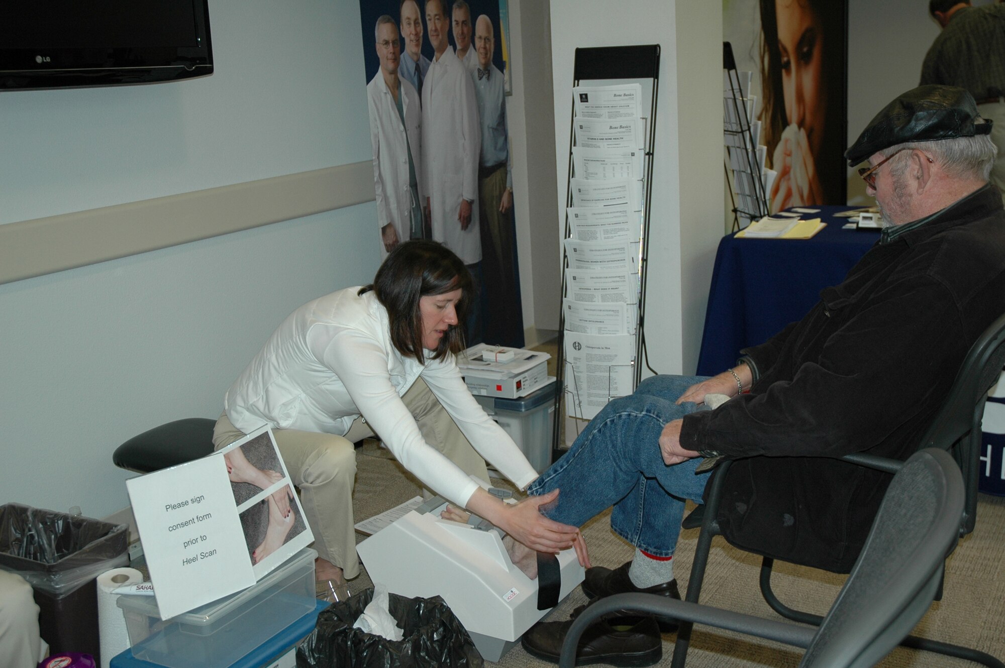 A new service this year offered at the Malmstrom Clinic during Retiree Appreciation Weekend was performing heel scans to check for bone density and osteoporosis. Adrienne Dube, from the Benefis Healthcare Spince Center,  positions William Eudy's foot in preparation of performing a scan on him. (U.S. Air Force photo/Valerie Mullett)